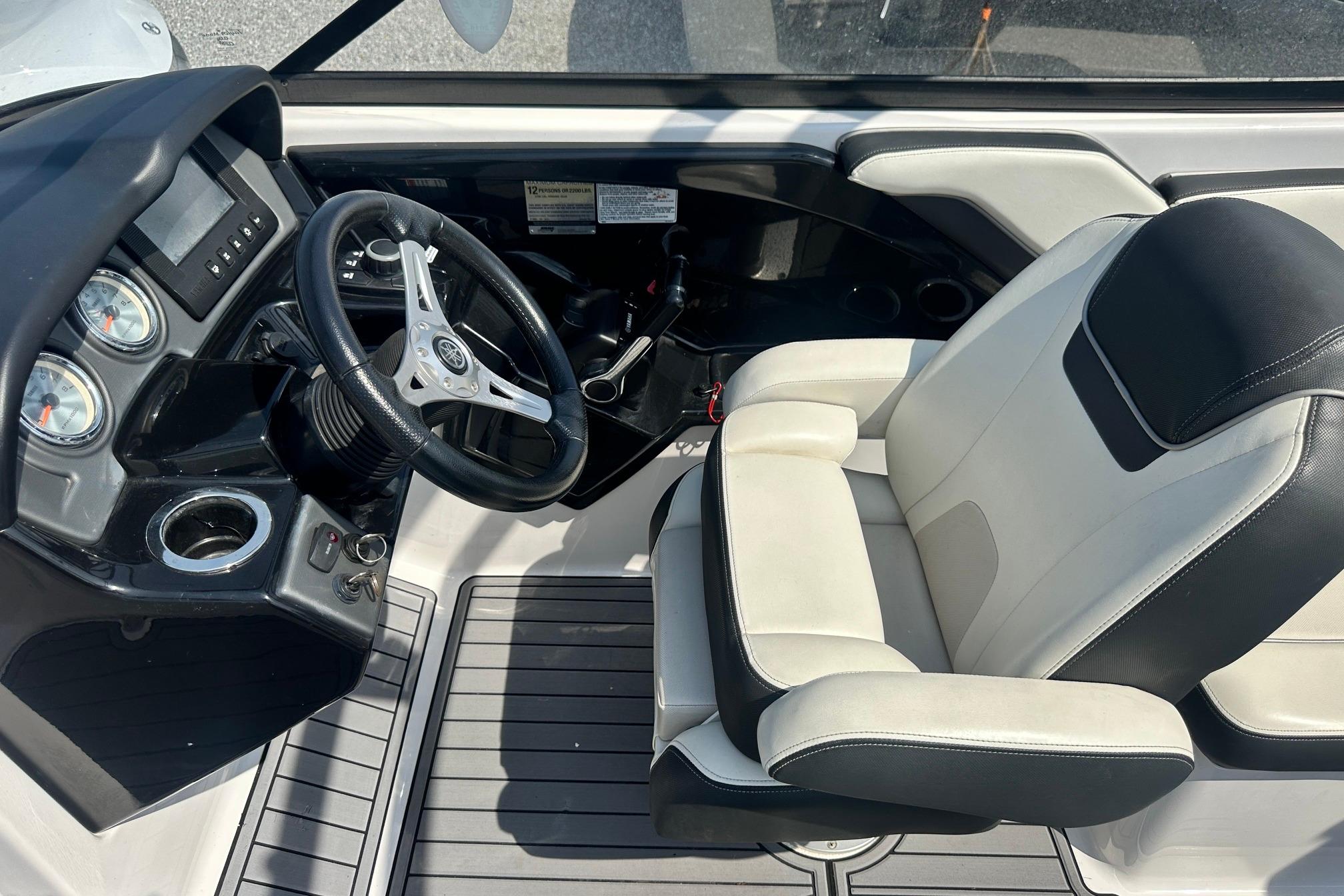 2016 Yamaha 242 Limited S boat cockpit with steering wheel and captain's seat.