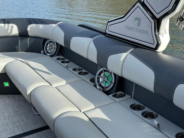 Luxurious seating on the 2025 Montara Surf Boss 2.0 25 boat with cup holders and speakers.