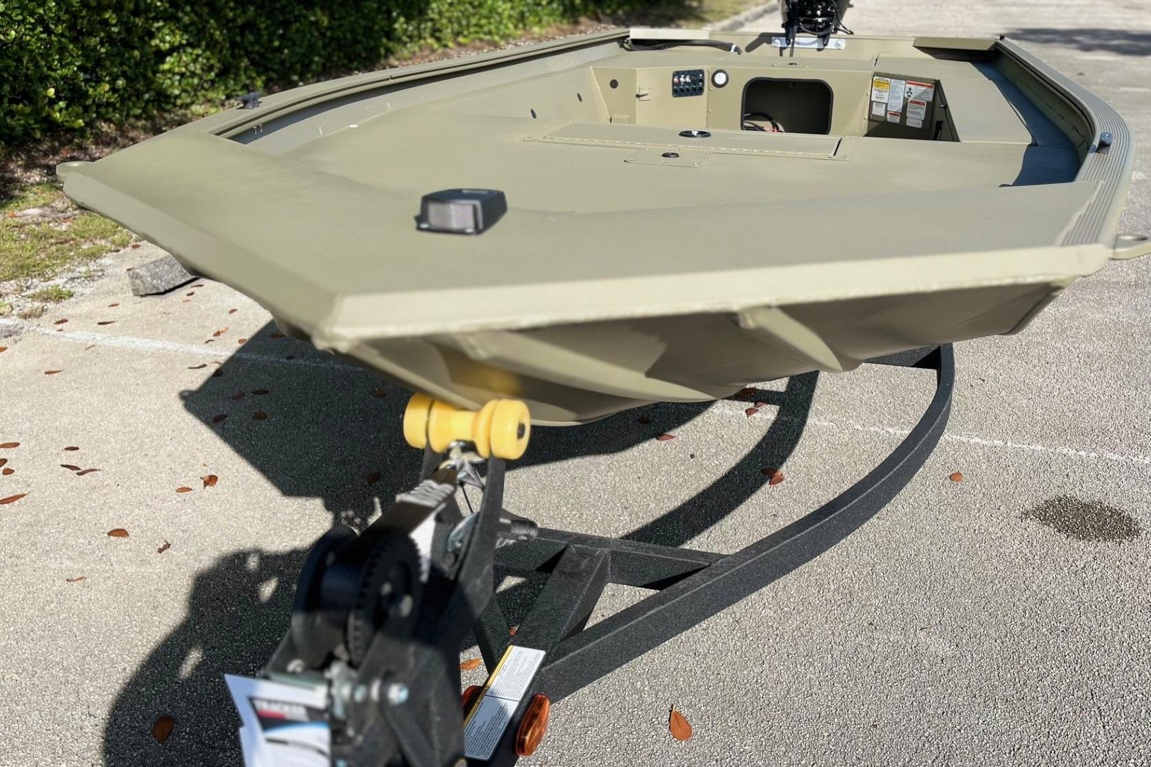 2026 Tracker Grizzly 1654 T Sportsman boat on trailer, parked outdoors.