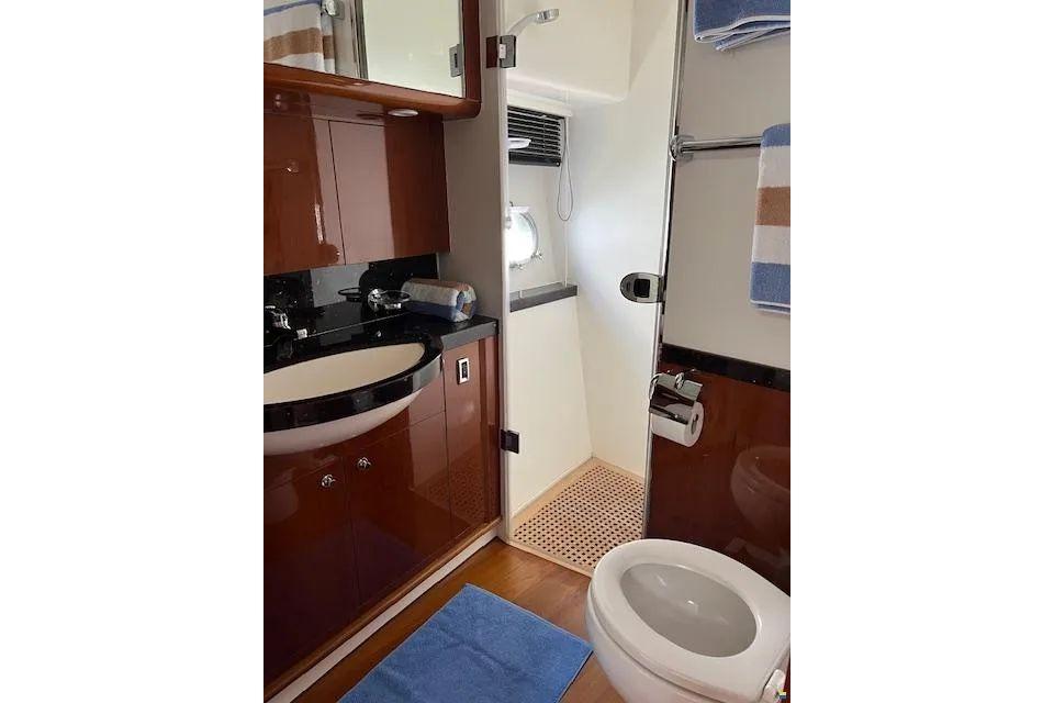 Bathroom interior of 2006 Princess 67 Flybridge Motor Yacht, featuring modern fixtures and wood cabinetry.