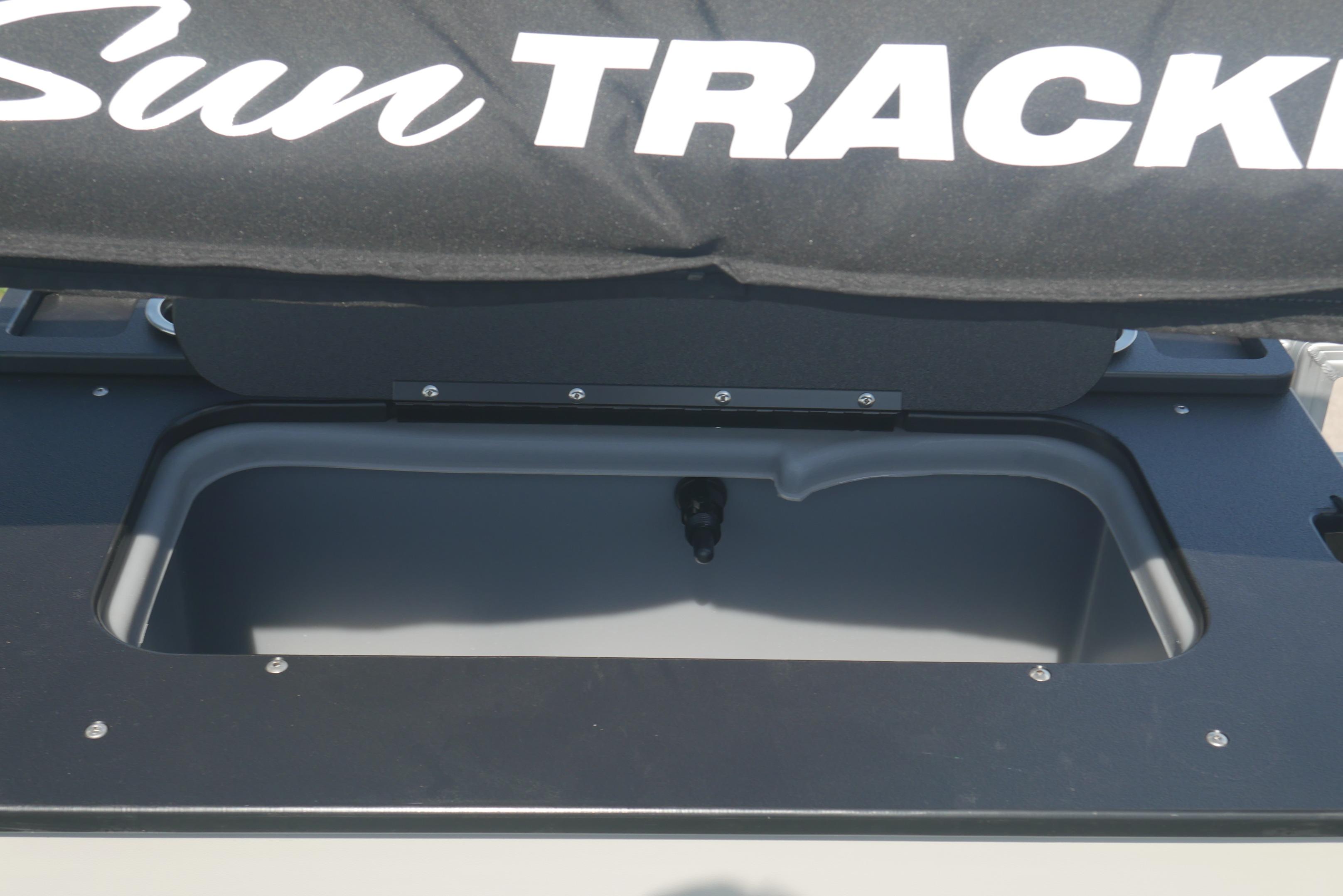 2026 Sun Tracker Fishin' Barge 20 DLX storage compartment with branded cover.