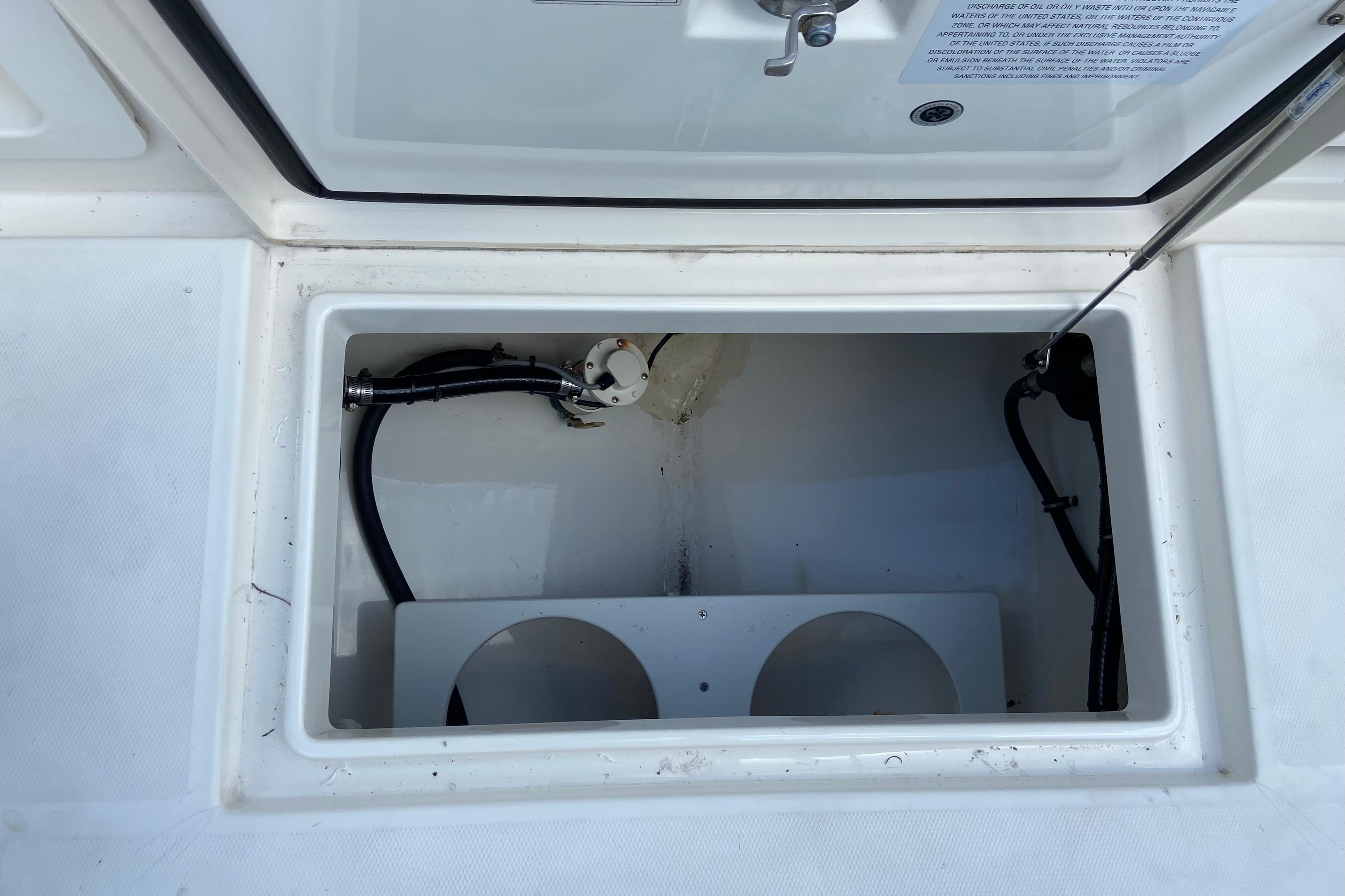 Open storage compartment on a 2021 Regulator 28 boat, showing interior details and wiring.