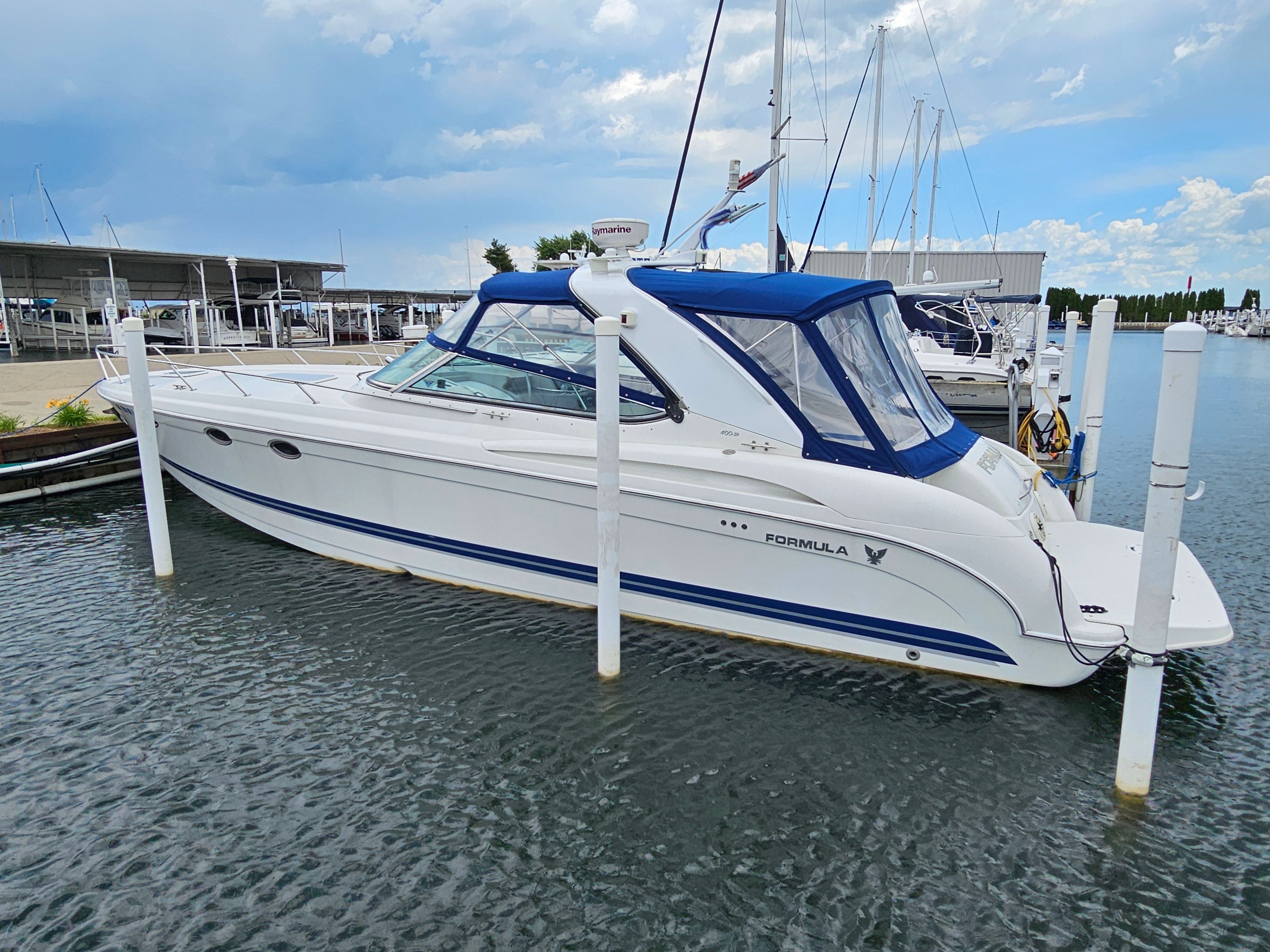 2001 Formula 400 Super Sport at dock with blue canopy.