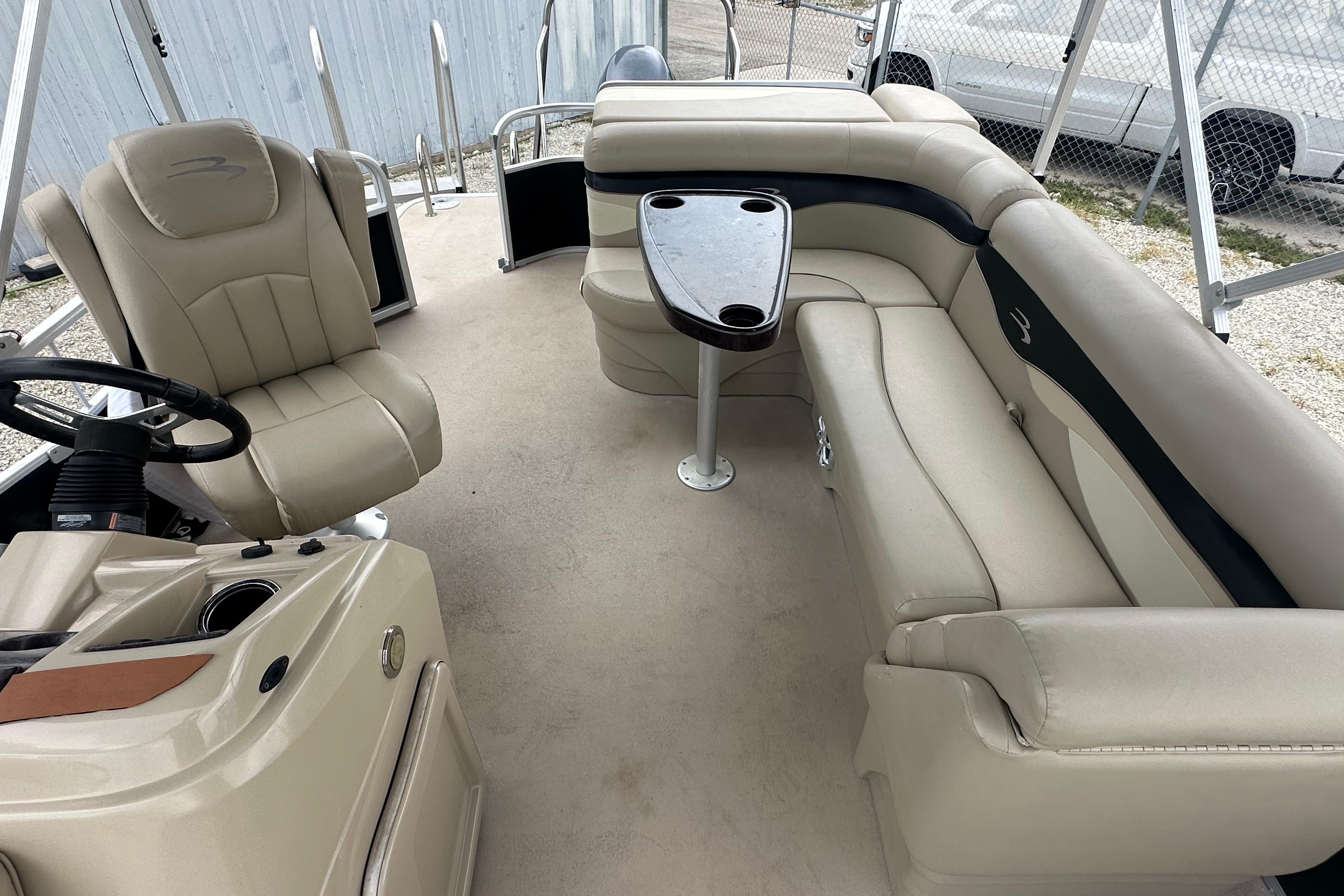 Interior of a 2014 Bennington S22 pontoon boat with beige seating and steering console.