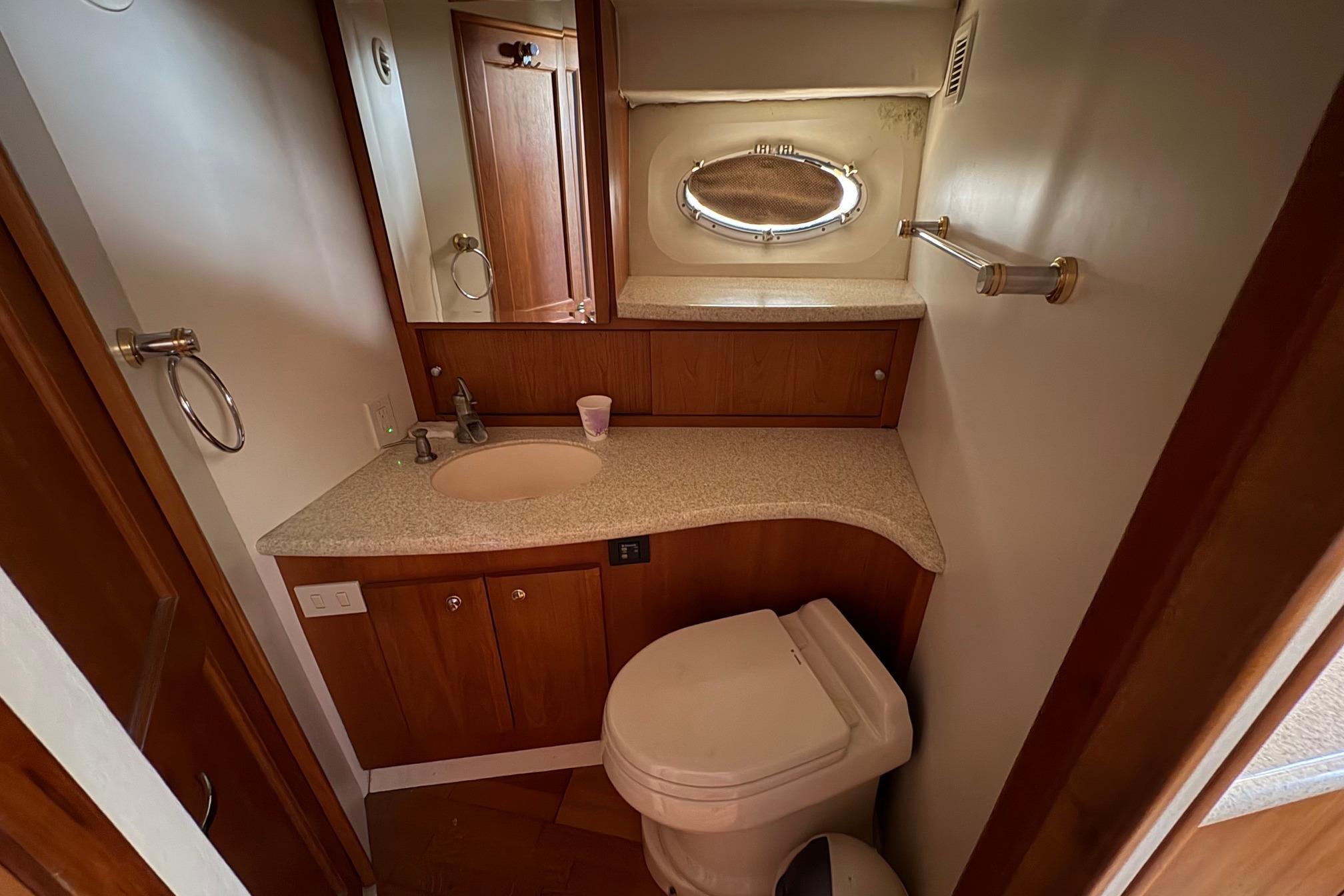 Bathroom interior of 2000 Silverton 42 Convertible yacht with sink and toilet.