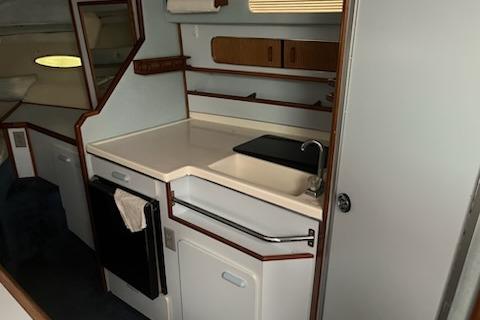1989 Sea Ray 300 Sundancer interior kitchen with sink, cabinets, and countertop.