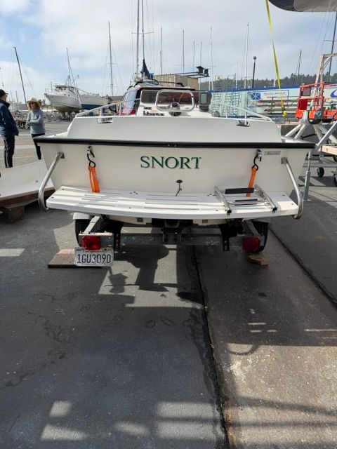 A 1992 Boston Whaler 13' jet boat on a trailer at the harbor.
