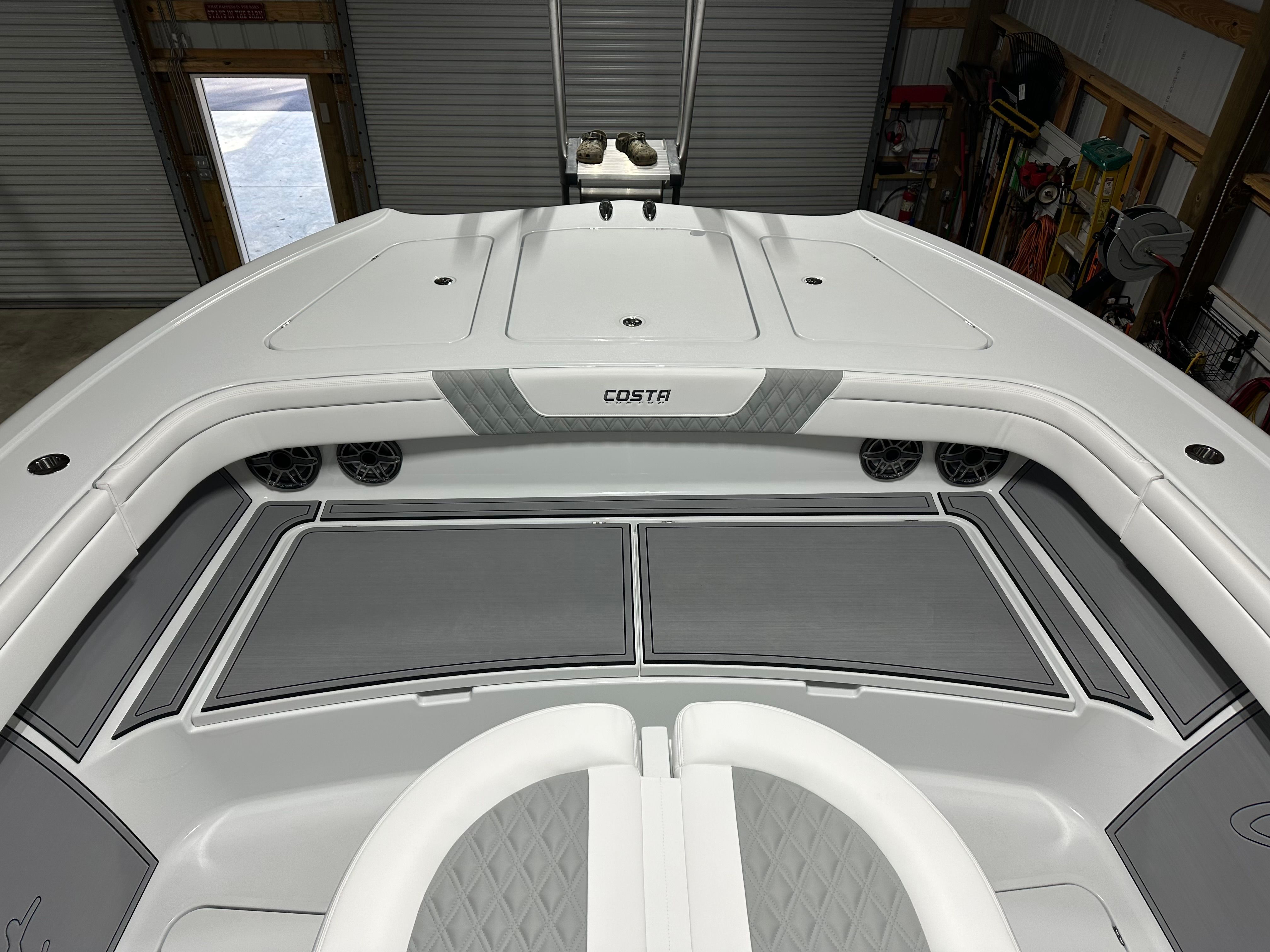 The boat features a modern white design with gray accents and cushioned seating.