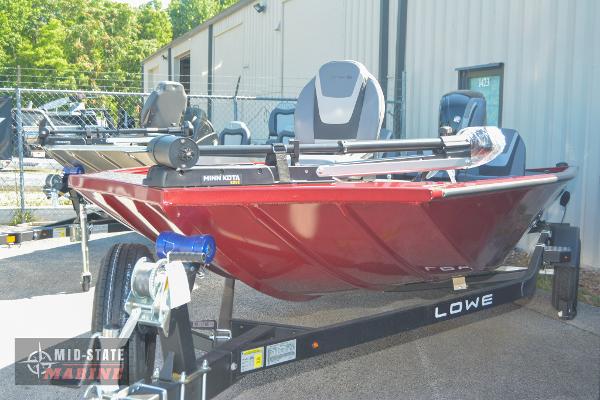 2024 Lowe Stinger 195 Bass boat in red on a trailer outside a warehouse.