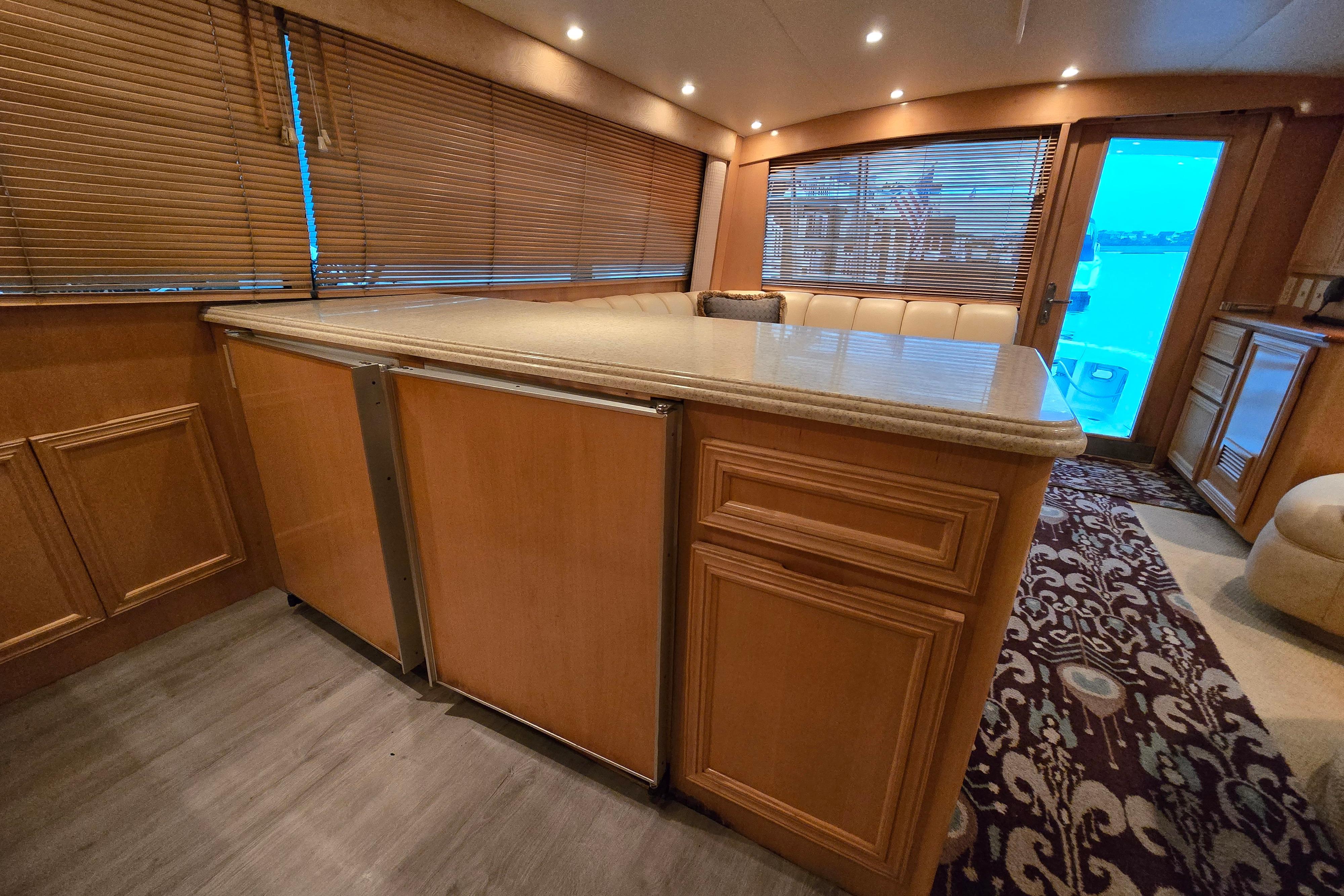 Luxurious interior of a 2001 Cavileer 53 Convertible yacht with wooden cabinetry and plush seating.