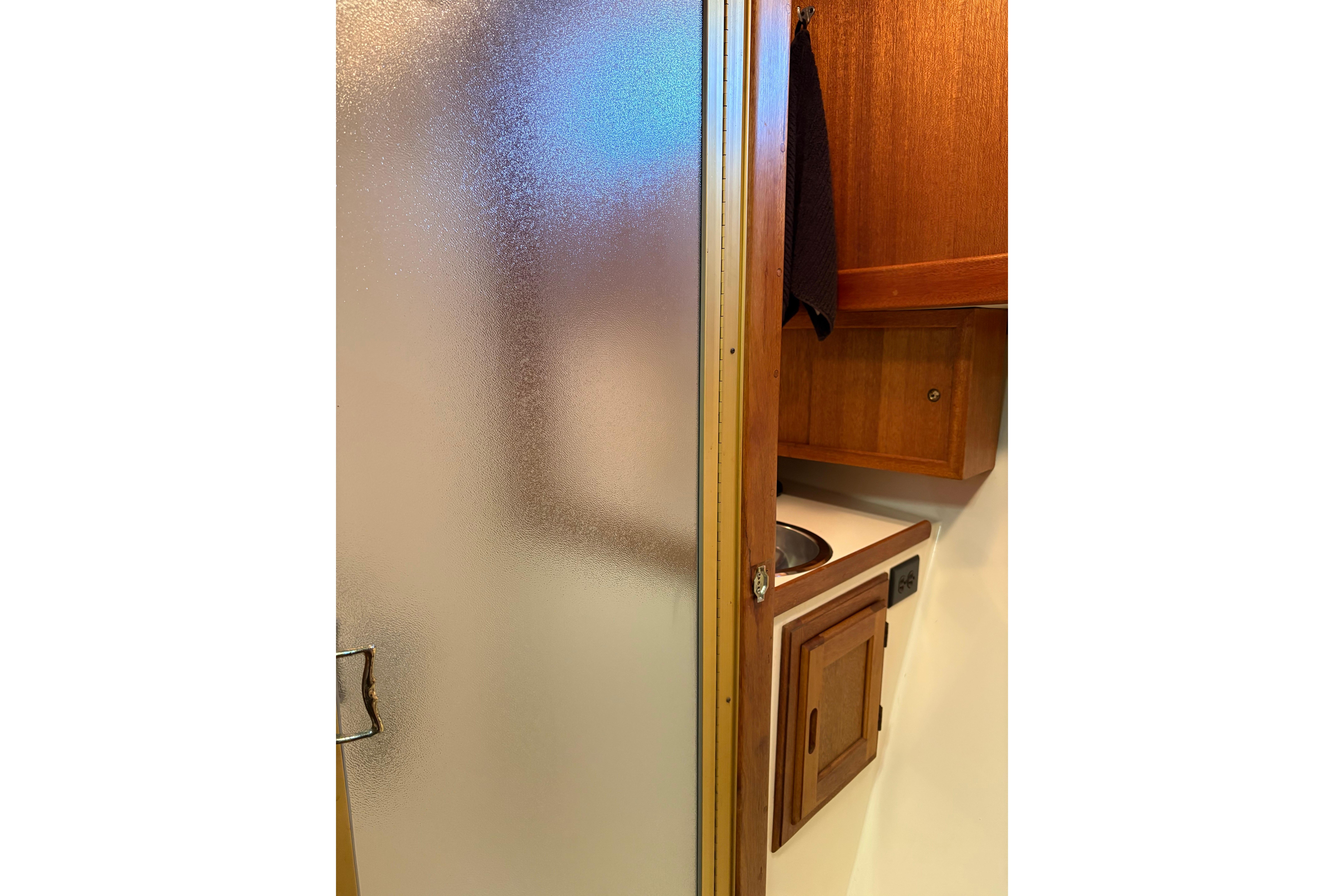 1978 Californian 42 LRC yacht interior with wooden cabinetry and frosted glass door.