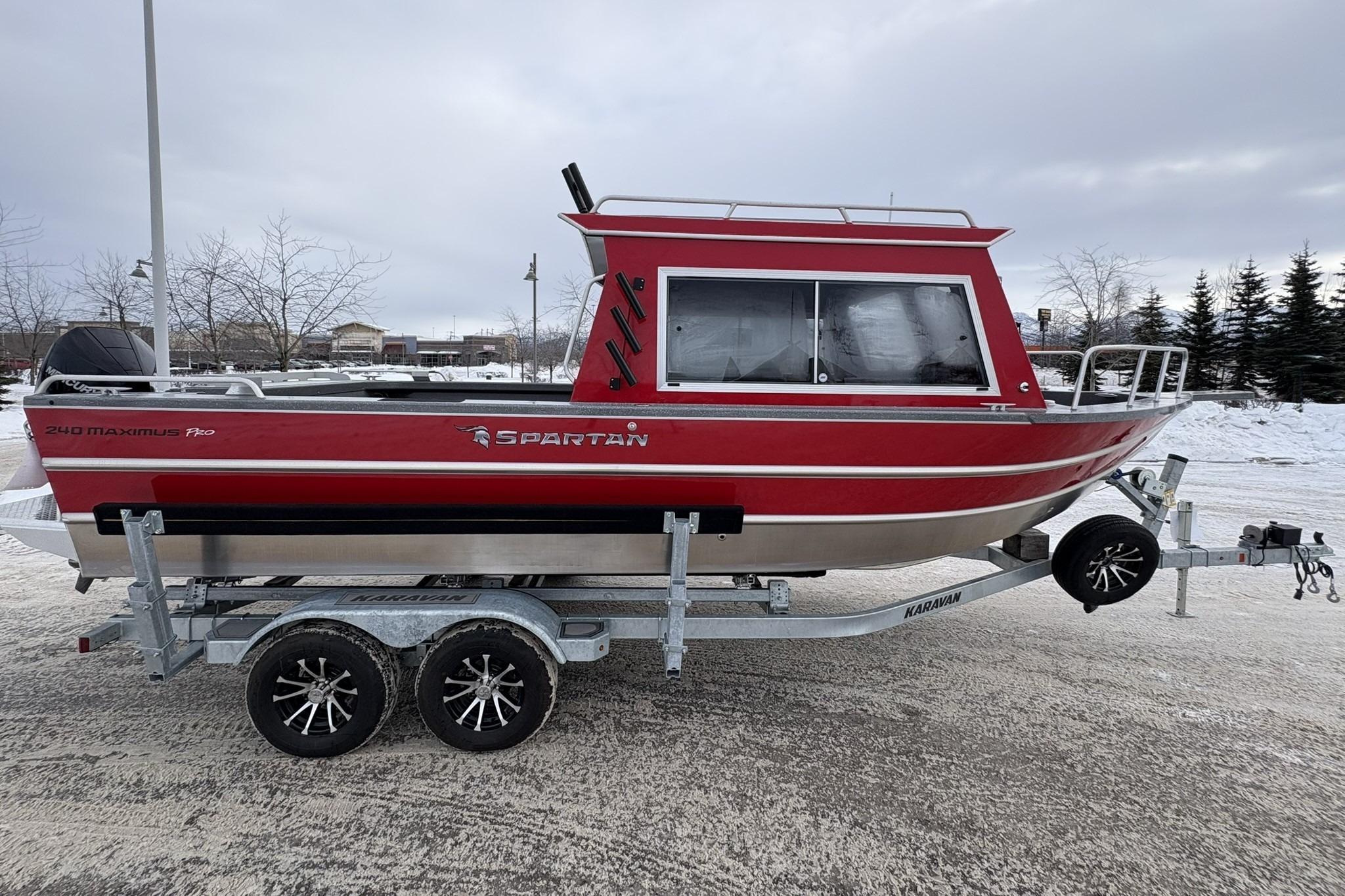 2024 Spartan 240 Maximus Pro boat on trailer, red exterior, parked in snowy lot.