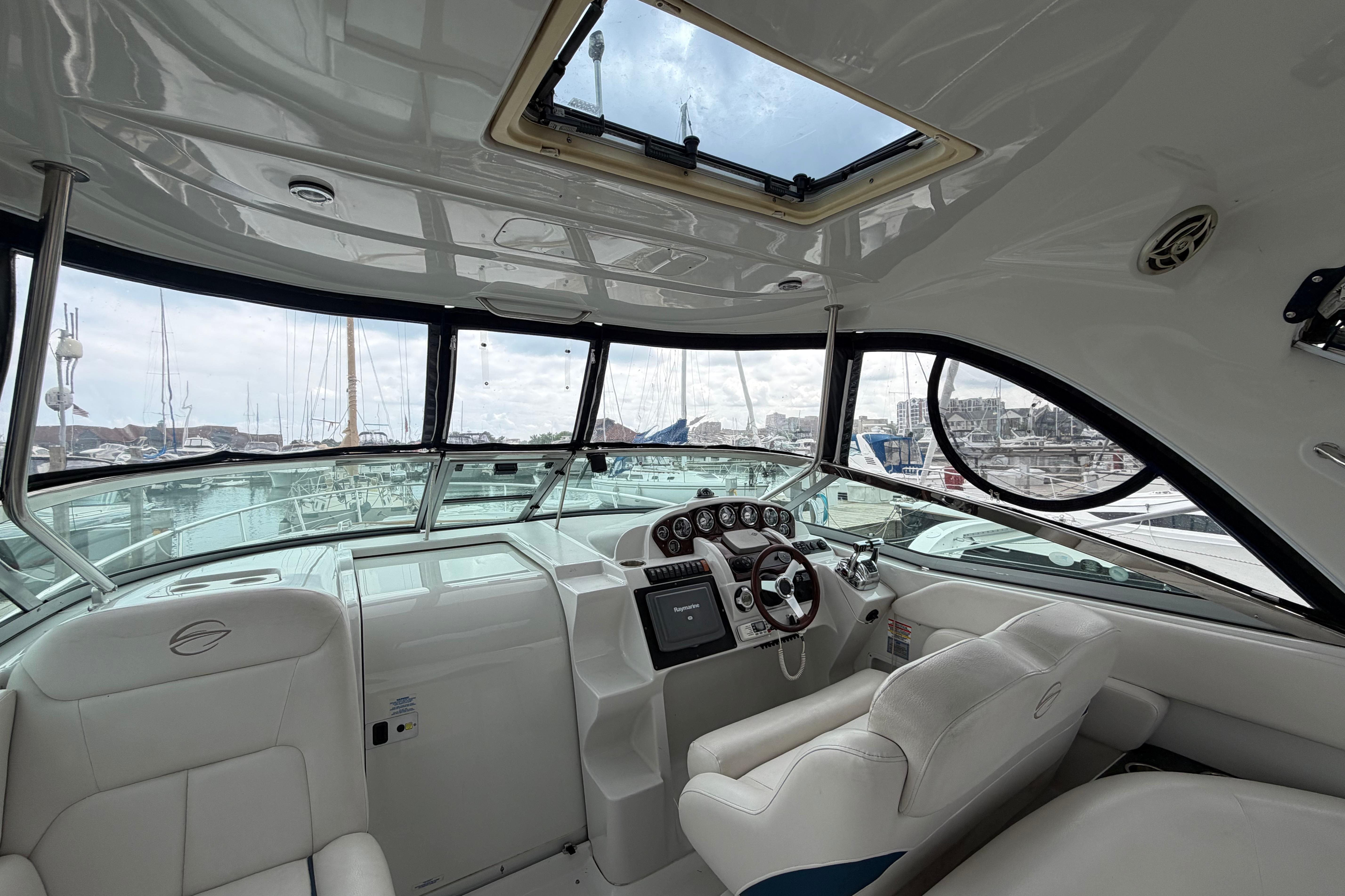 Interior view of a 2008 Crownline 340 CR yacht cockpit with marina background.