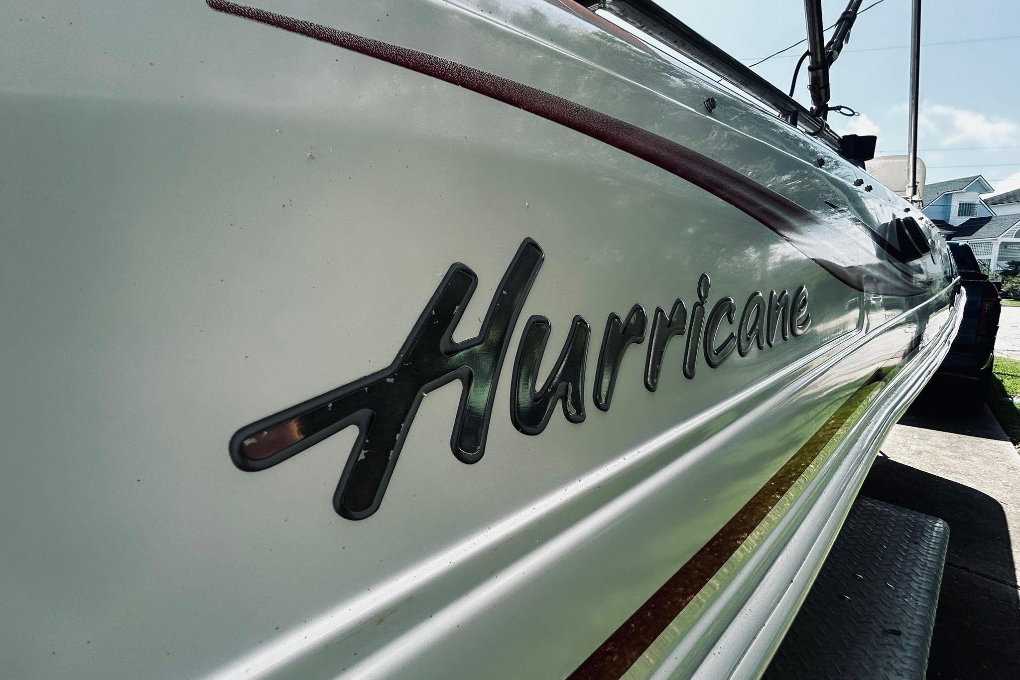 2013 Hurricane SunDeck Sport 201 OB boat with logo, parked outdoors.