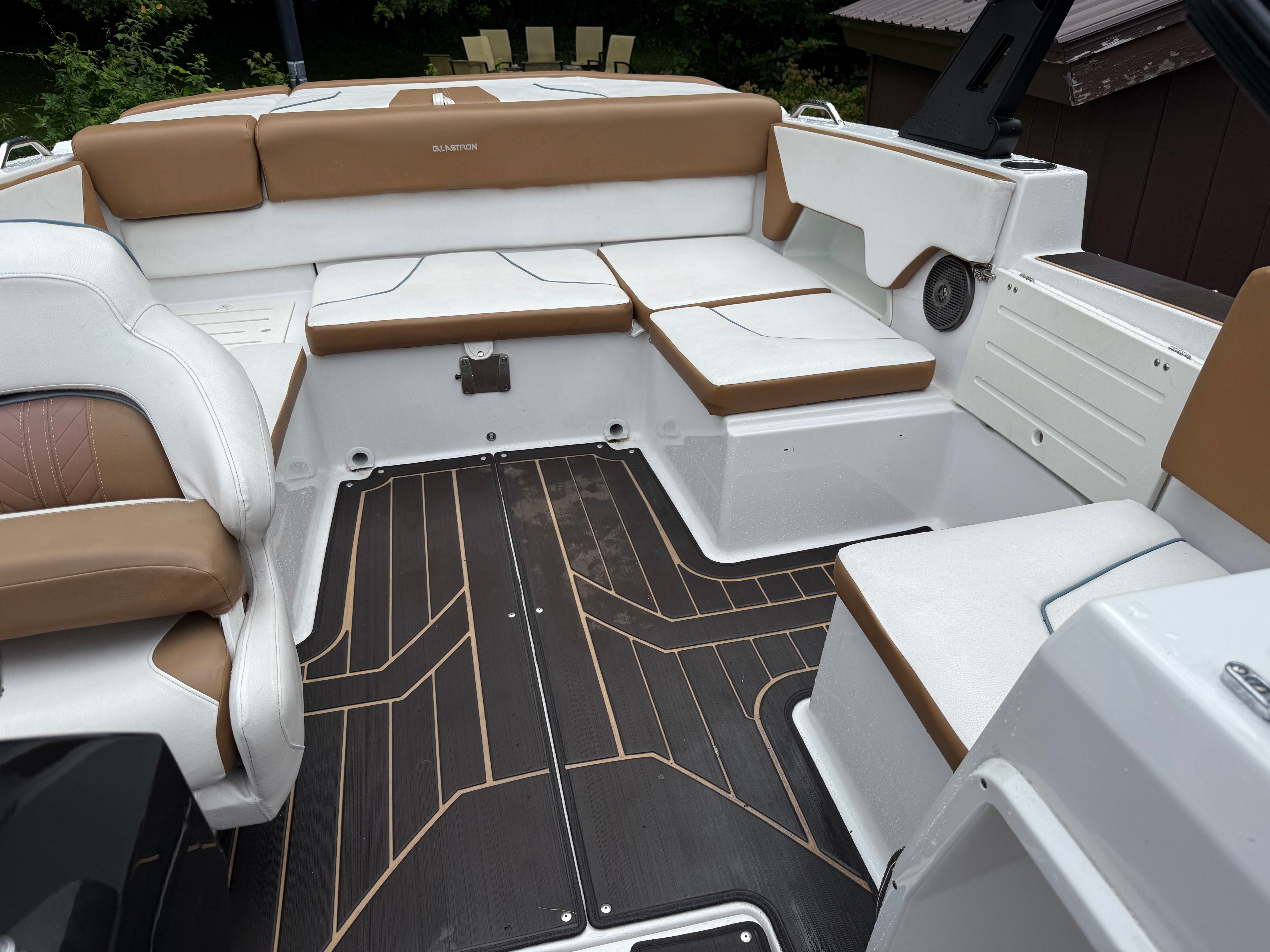 The image shows the cockpit of a 2019 Glastron GTDW 225 with brown and white seating.