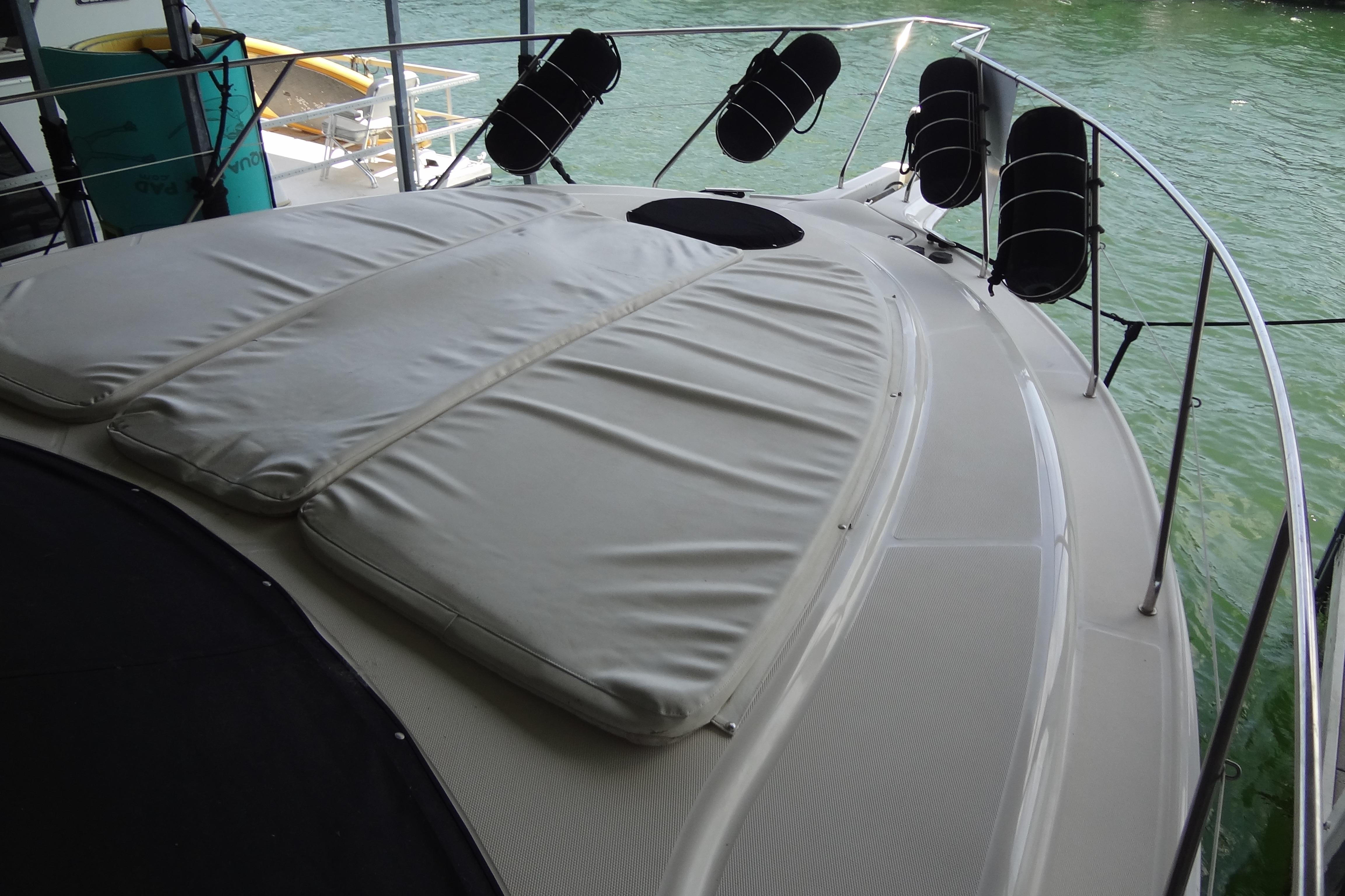2005 Silverton 34 Convertible yacht with cushioned deck, docked on calm water.