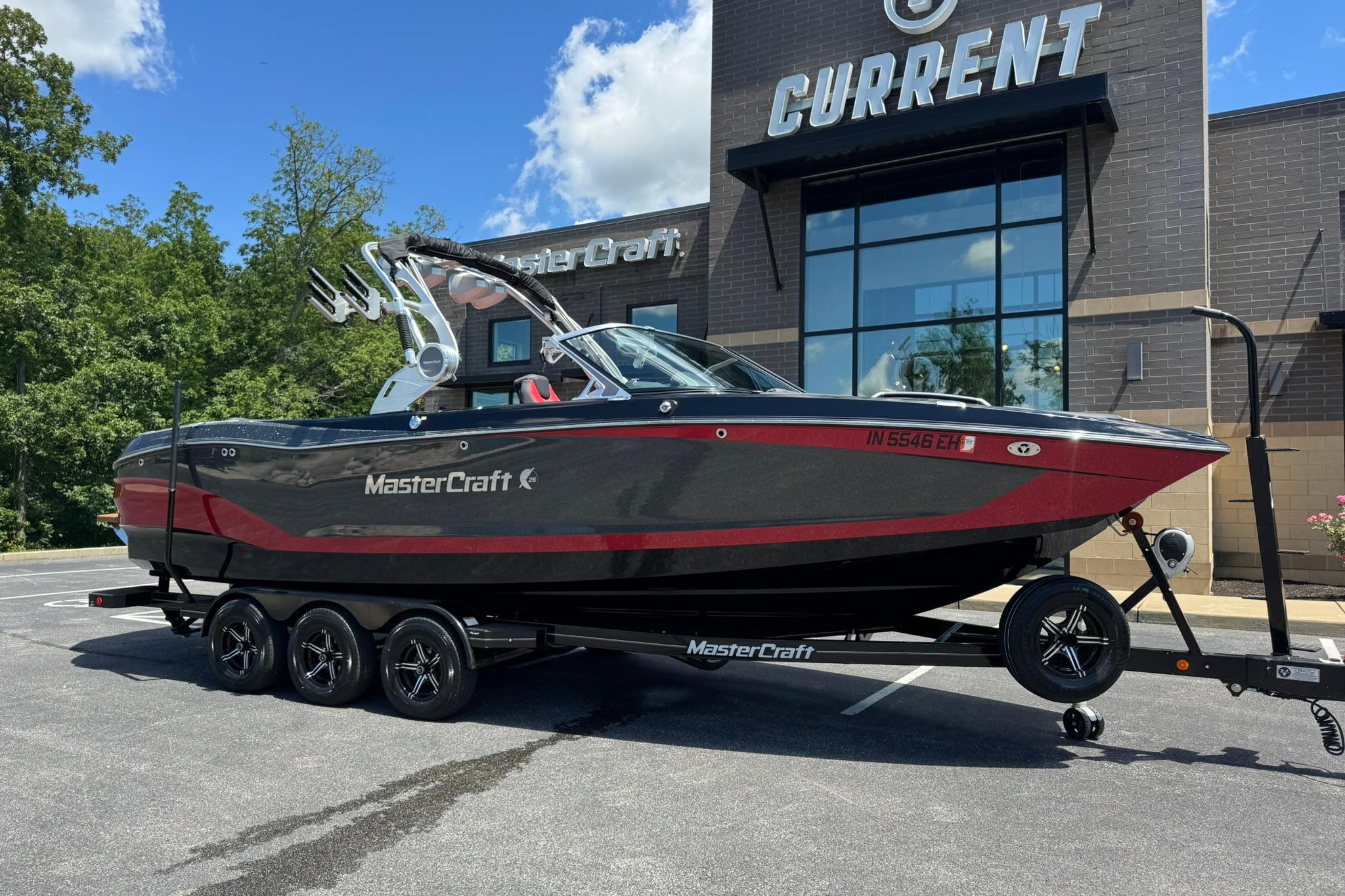 2021 MasterCraft X26 boat on trailer outside dealership, sunny day.