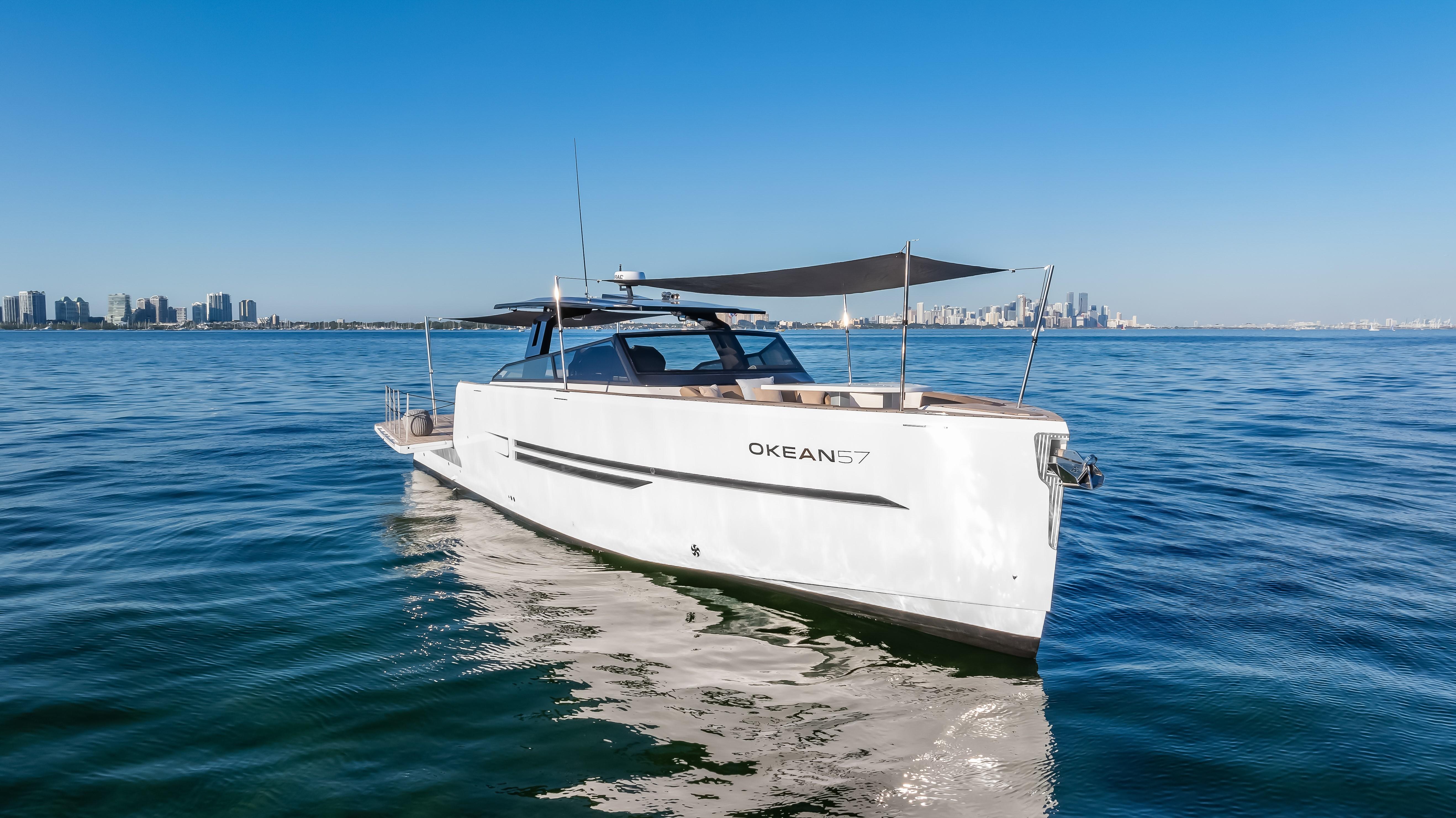 2026 OKEAN 57 yacht cruising on open water under clear blue sky.