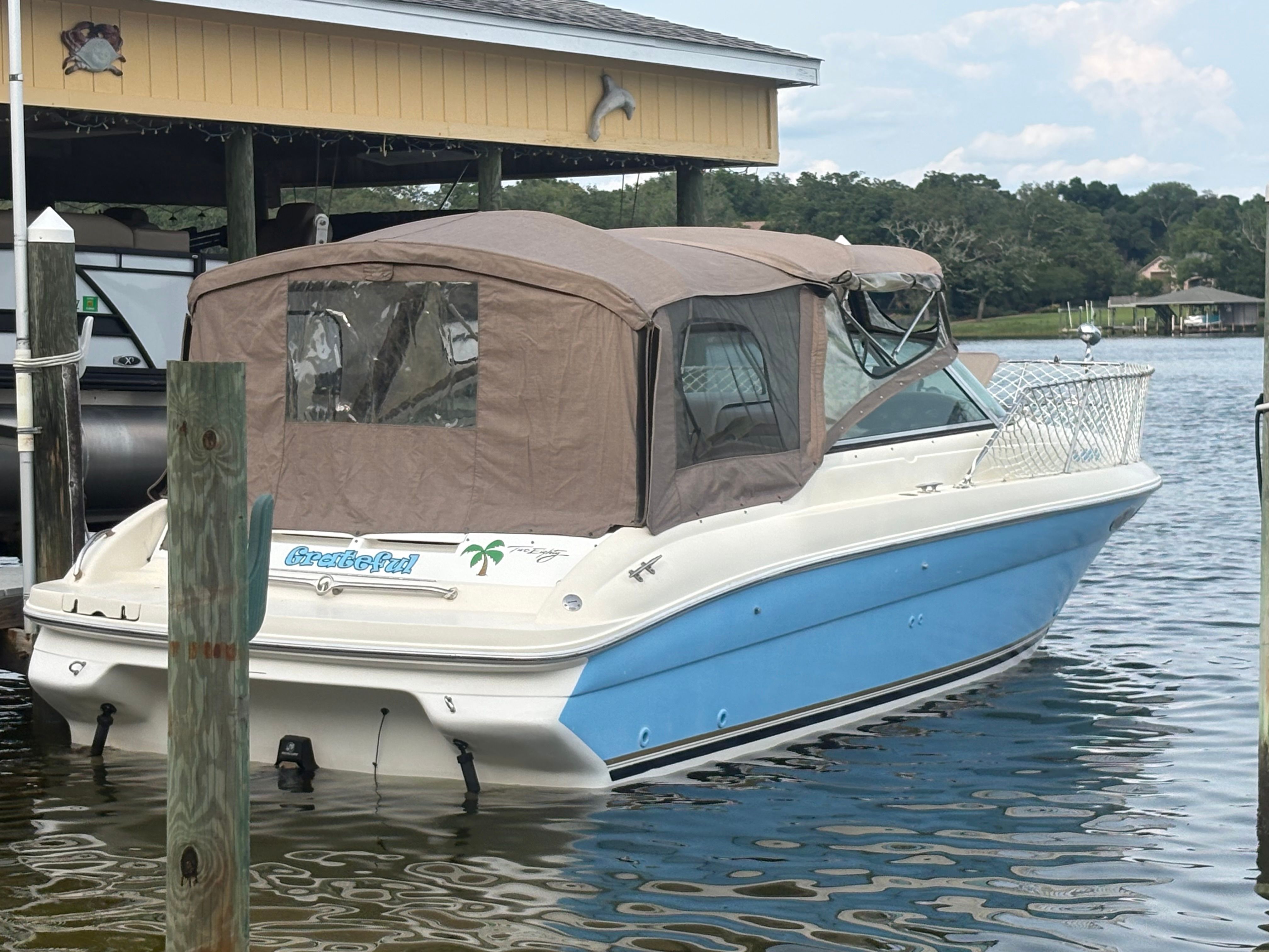 A 1996 Sea Ray 280 Cuddy Cabin boat docked on the water.