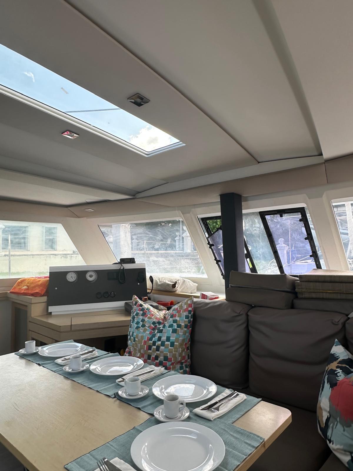 Interior of 2019 Fountaine Pajot Lucia 40 catamaran with dining setup and skylight.