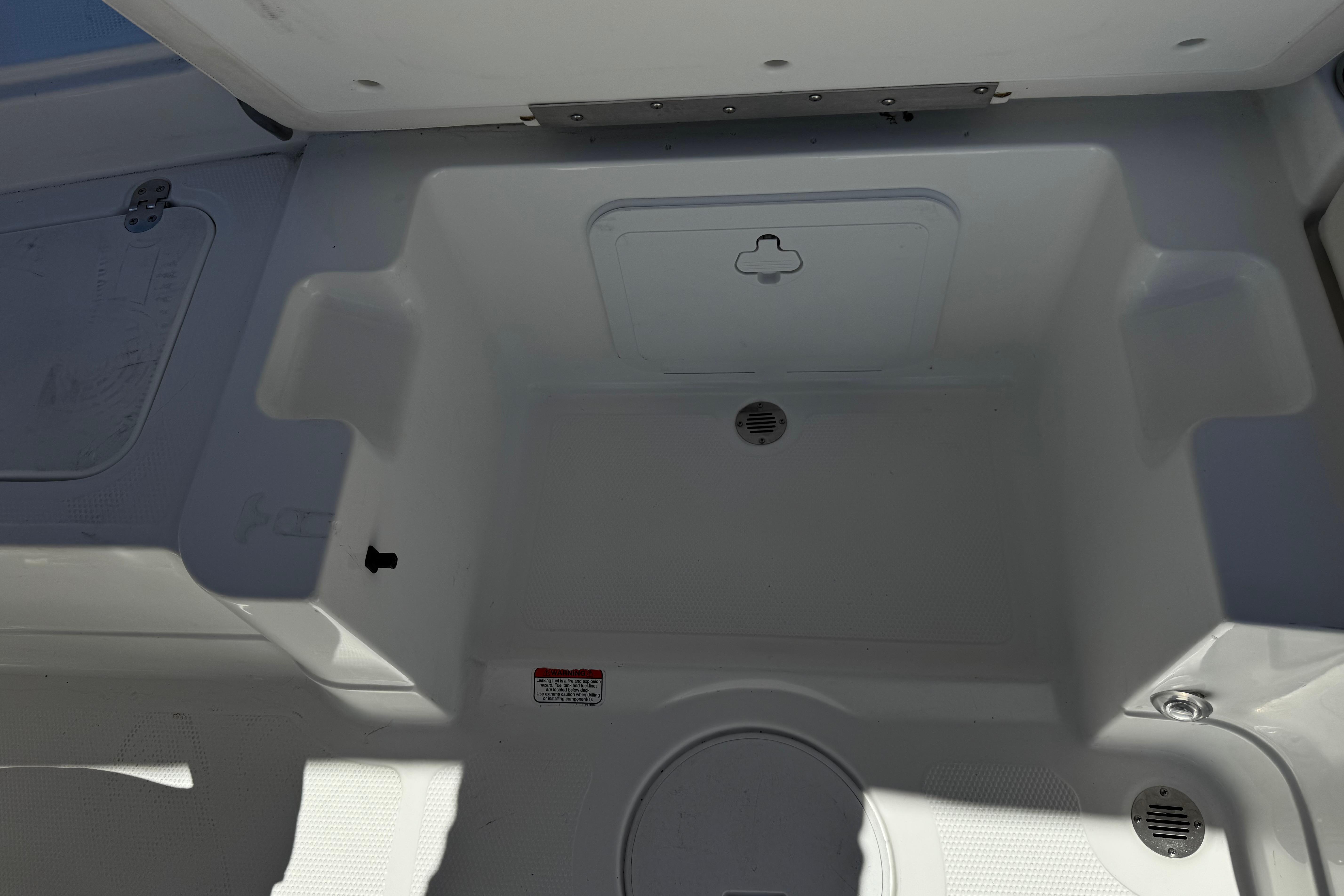 2017 Tahoe 2150 boat storage compartment with drain plug and hatch.