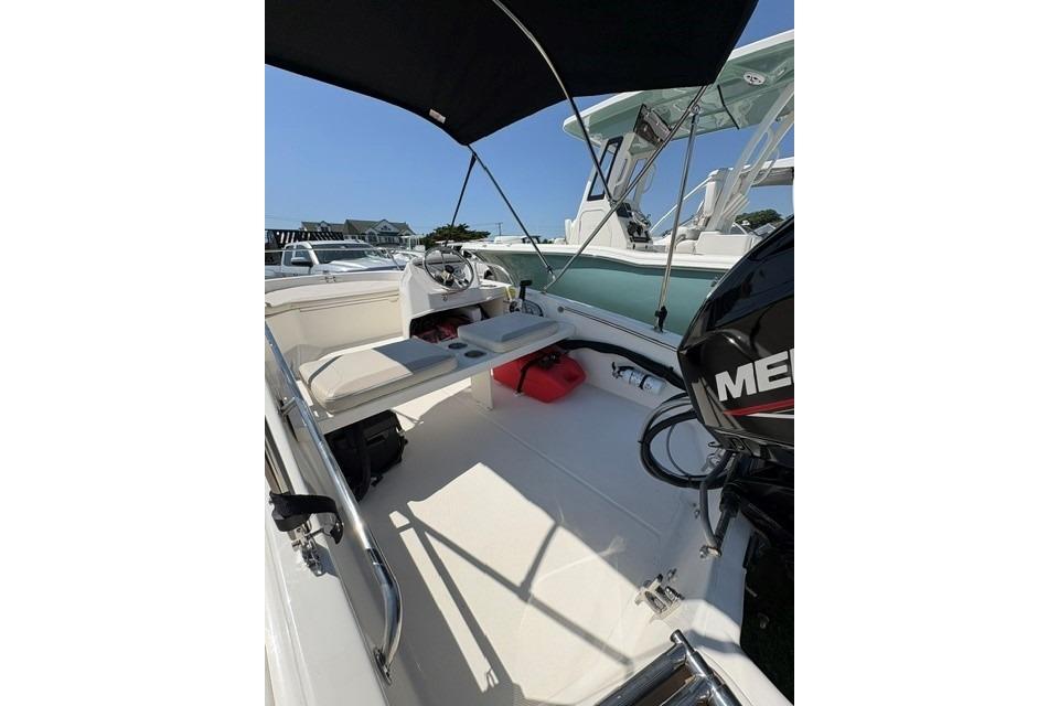 2024 Boston Whaler 130 Super Sport boat interior with seating and canopy.
