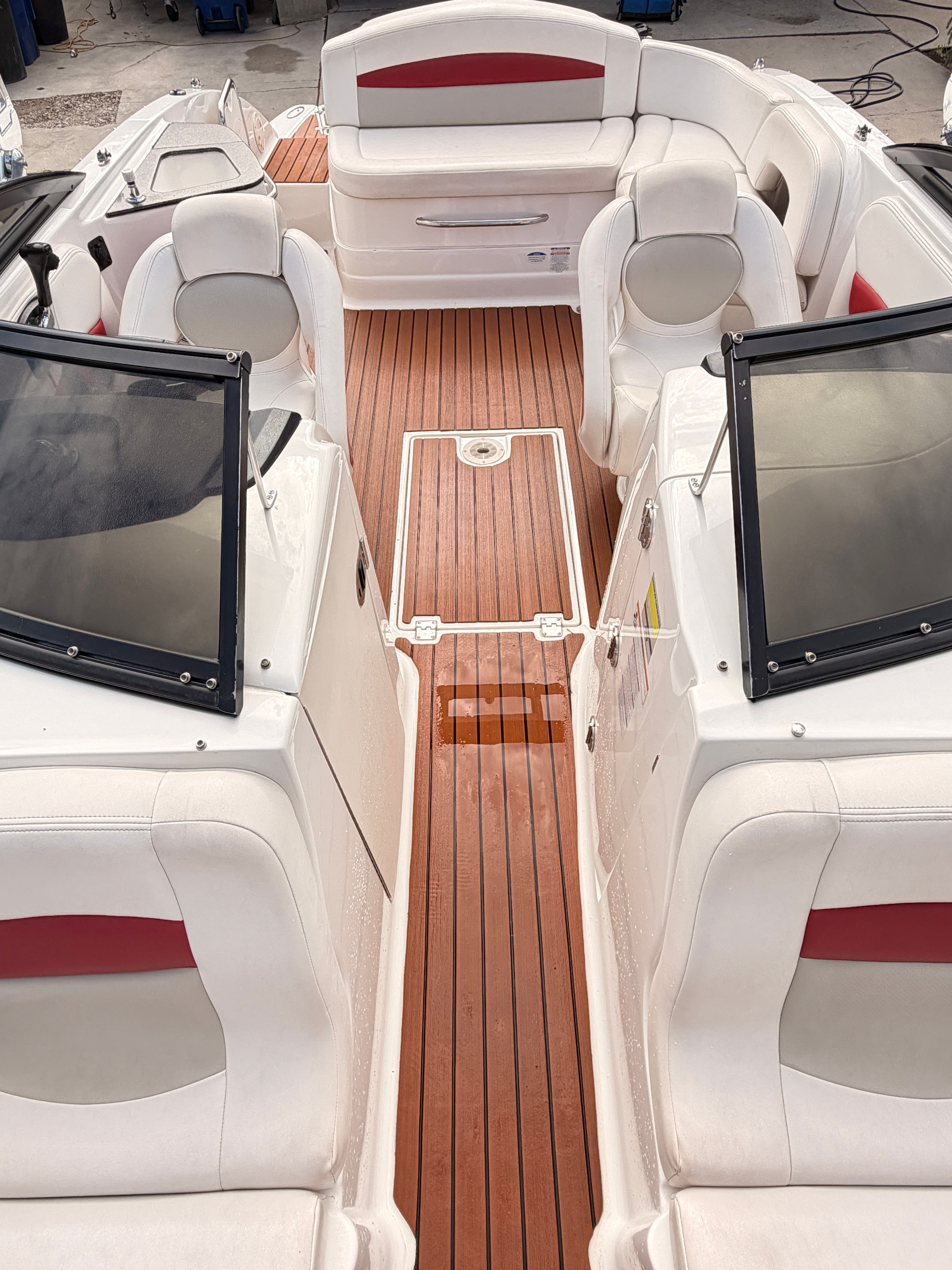The image shows the cockpit of a 2008 Chaparral Sunesta 224 with white seating and wood flooring.