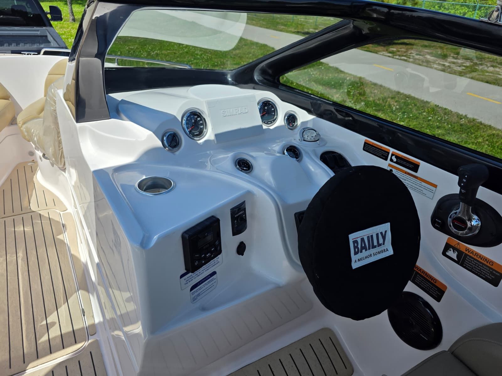 The image shows the cockpit of a Coral 26 boat with modern instruments and a steering wheel.