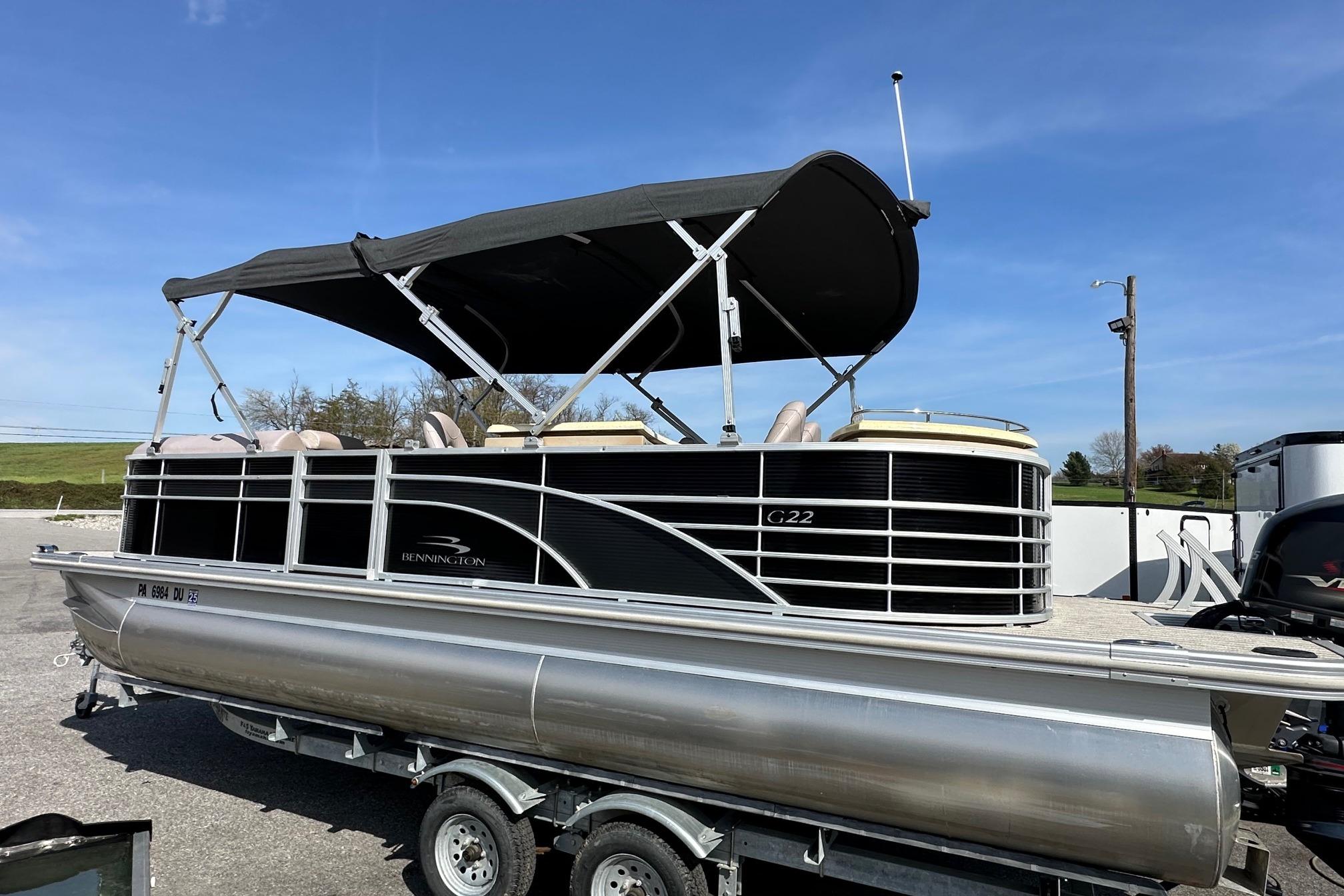 2017 Bennington 22 GPD pontoon boat with canopy on trailer, parked outdoors.