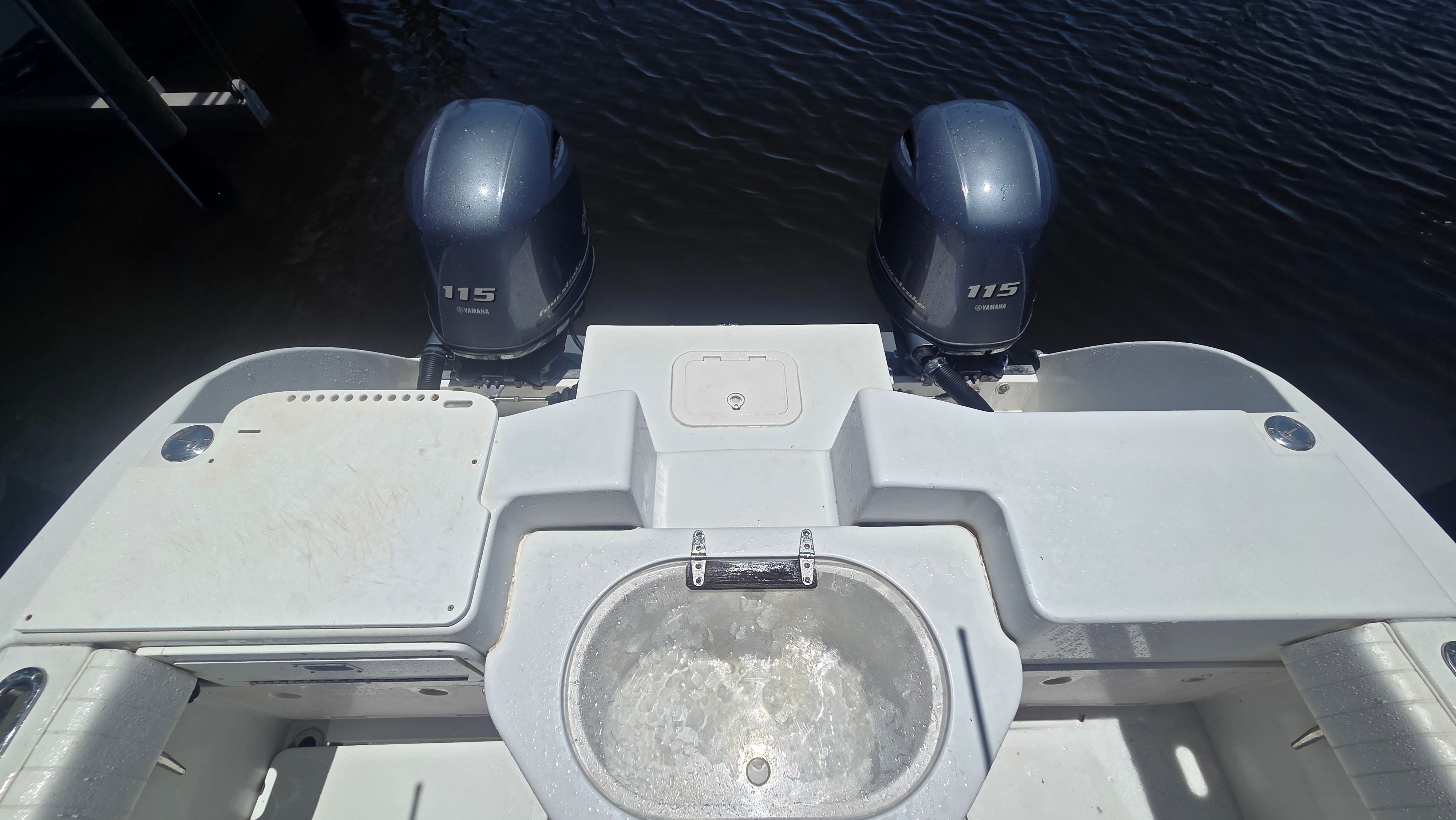 Stern view of a boat with two outboard motors and a round sink.