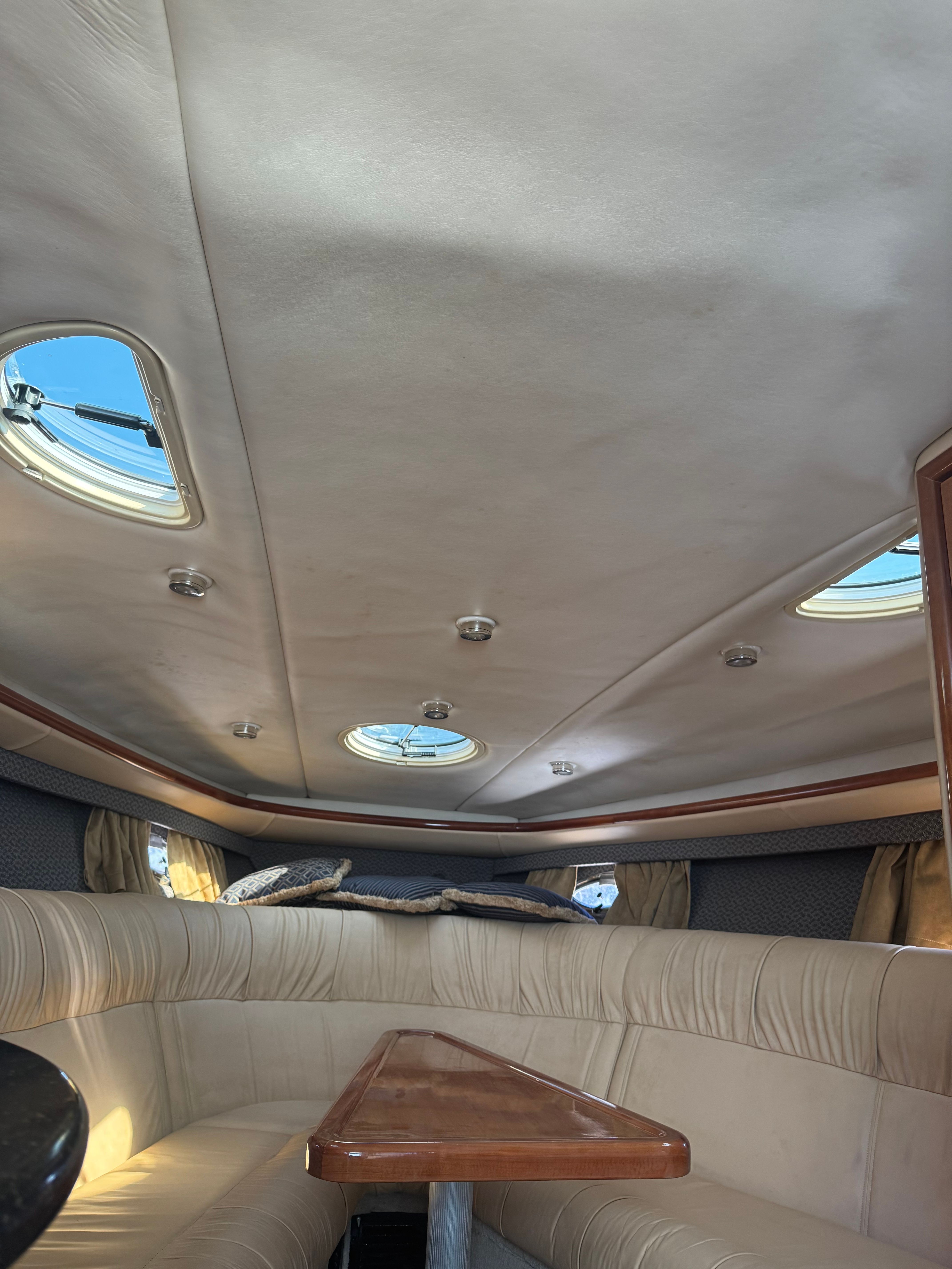 Interior of a 2003 Cobalt 360 with cushioned seating and skylights.