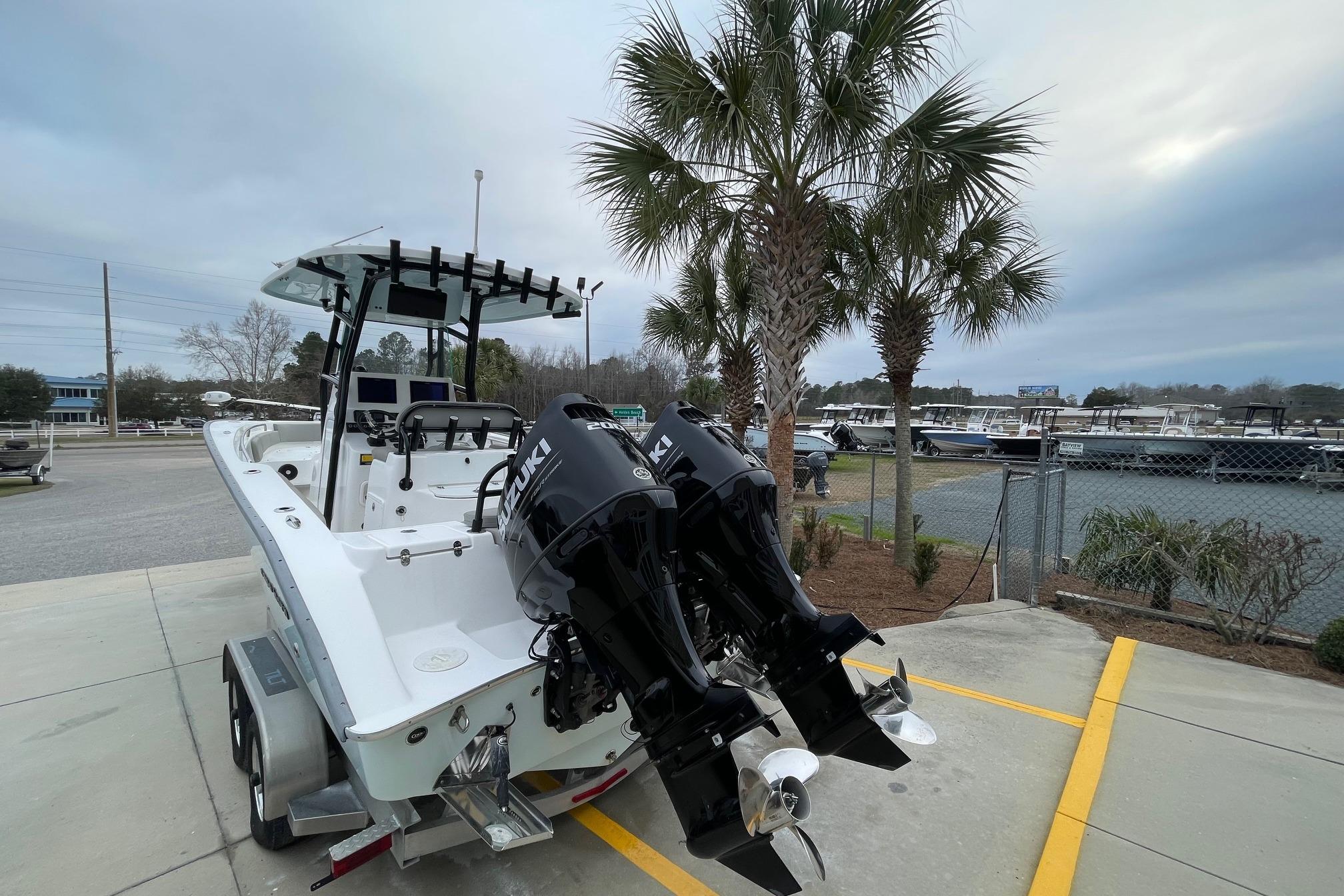 2023 Cape Horn 24 XS boat with dual Suzuki engines, parked near palm trees.