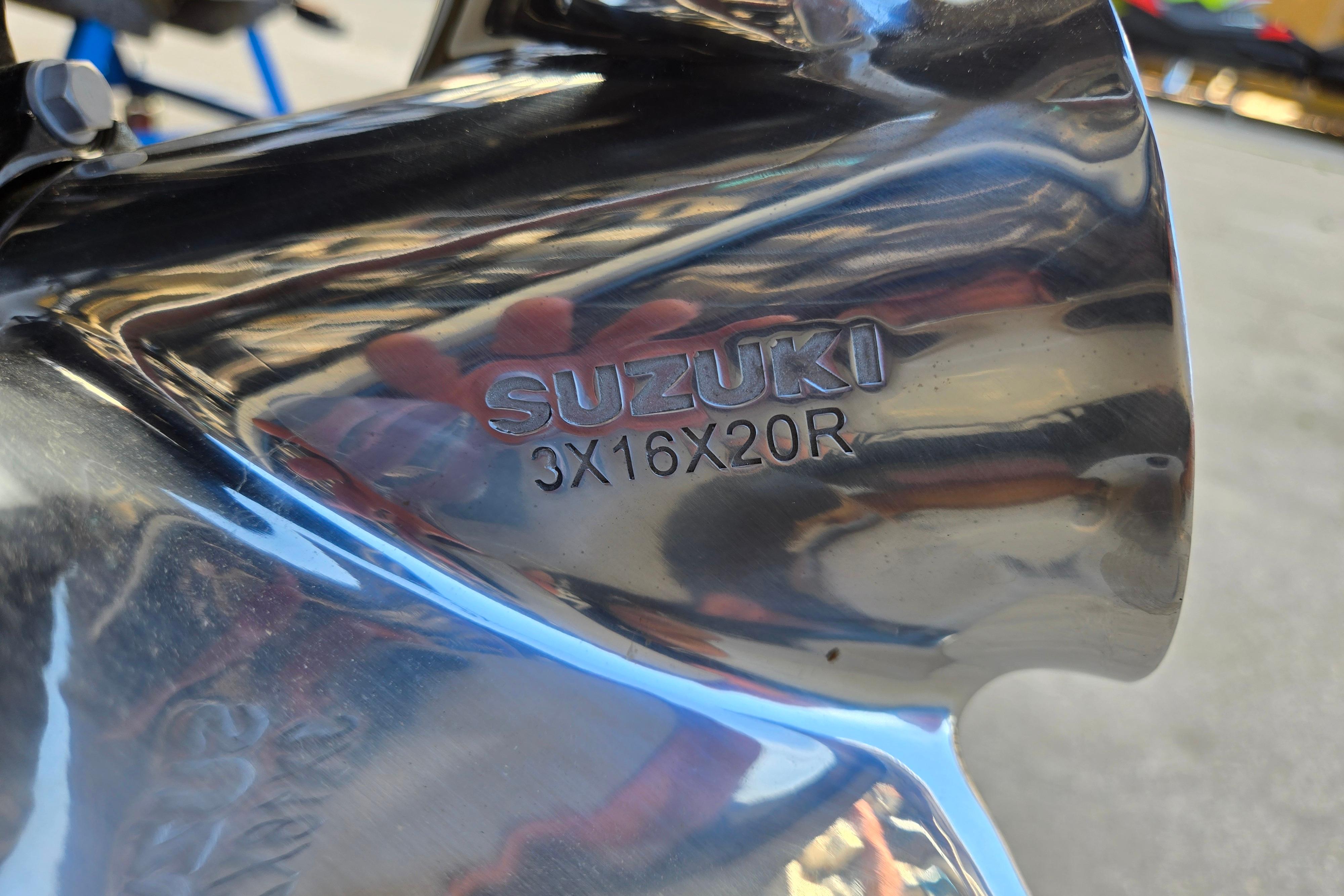 Close-up of a Suzuki propeller with model number 3X16X20R, reflecting light.