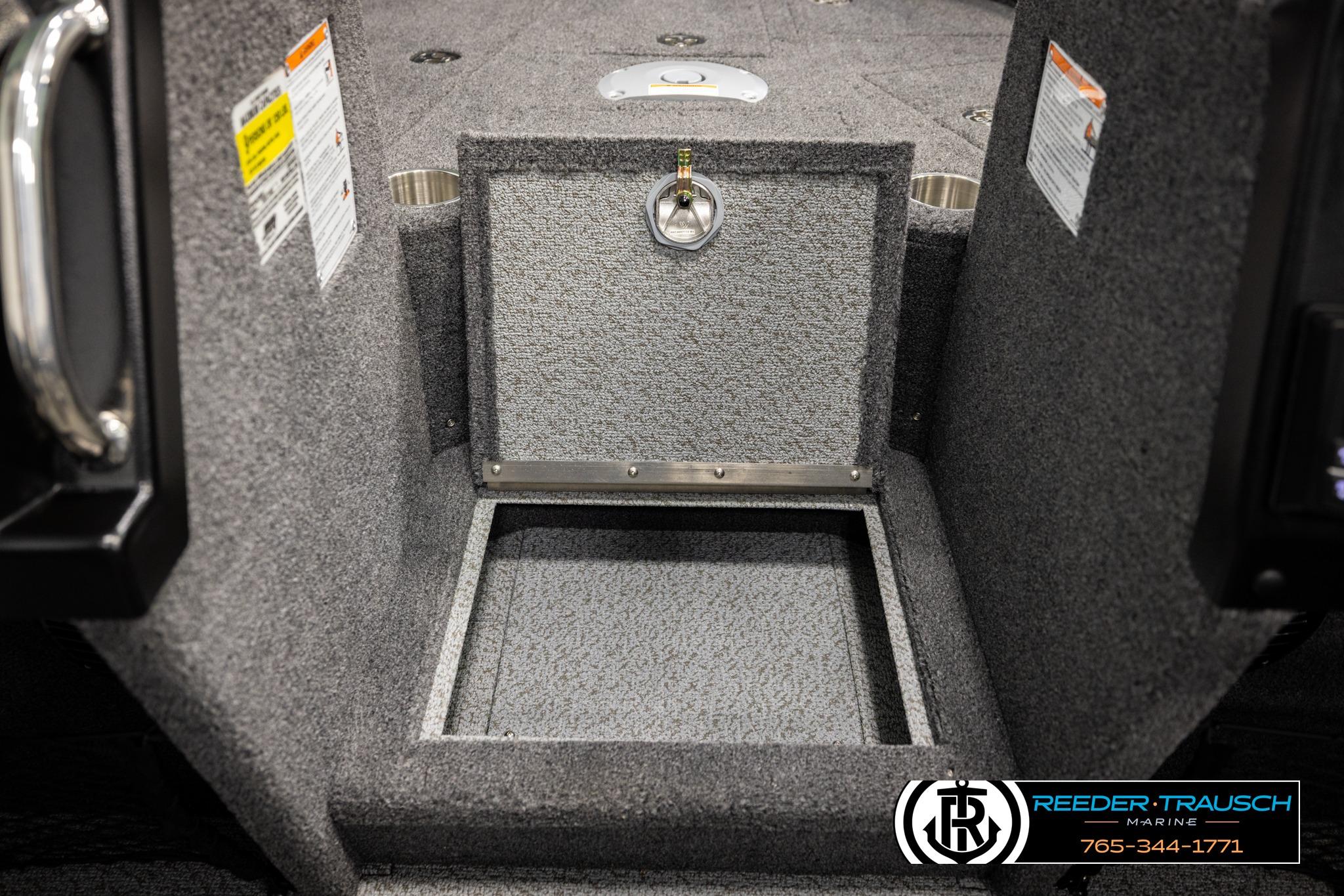 Interior storage compartment of 2026 Lund 1975 Tyee boat, featuring carpeted finish and secure latch.