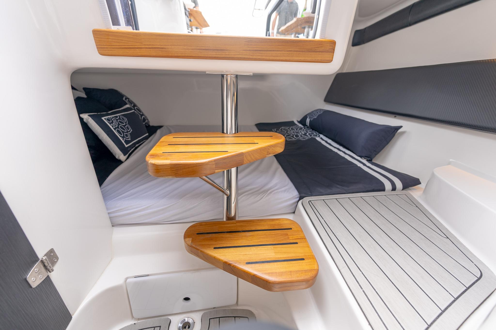 Interior of 2027 Hanover 305 boat with wooden steps and cozy bedding.