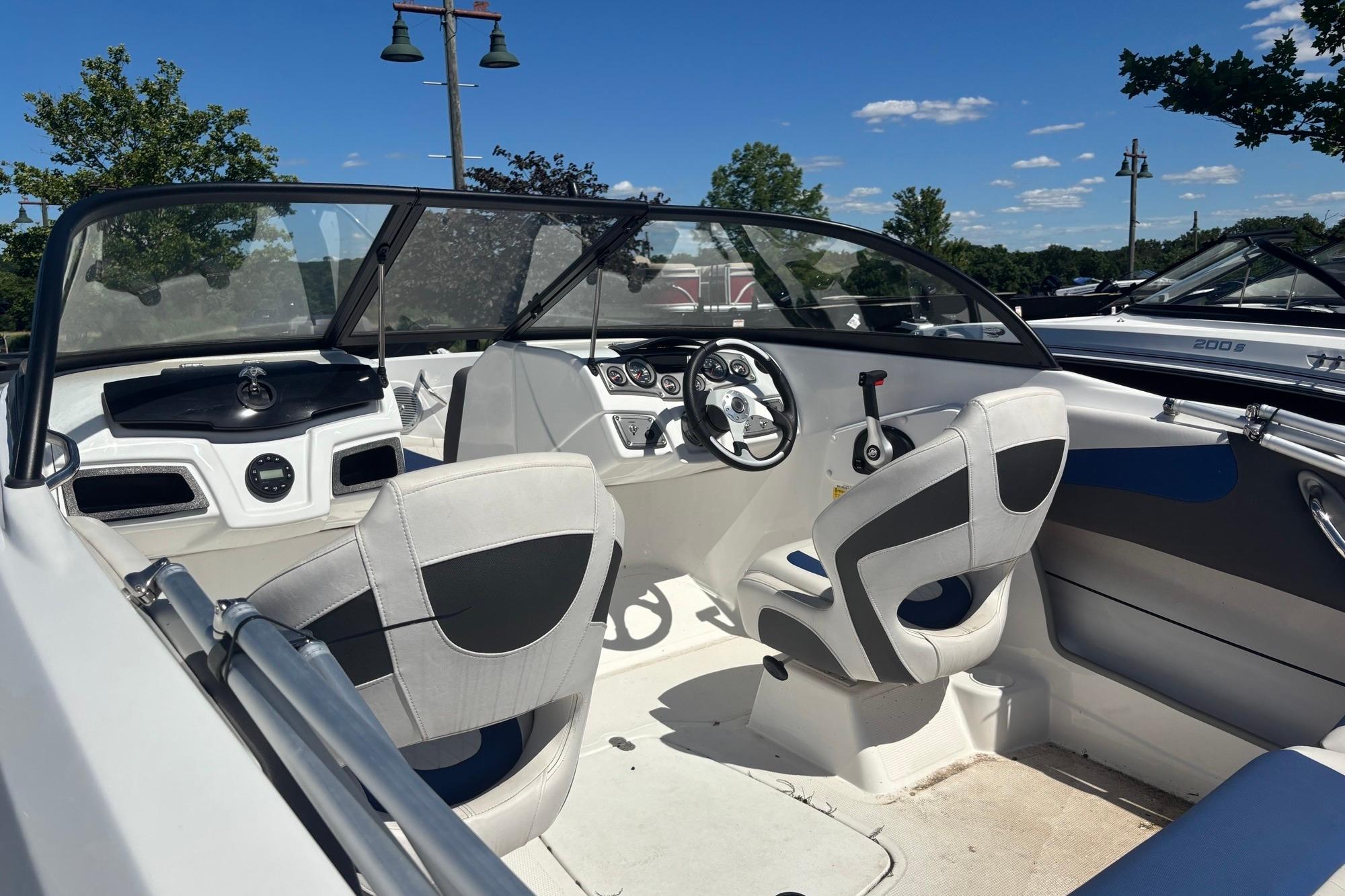 2024 Tahoe 200 S boat interior with steering wheel and seating under clear blue sky.