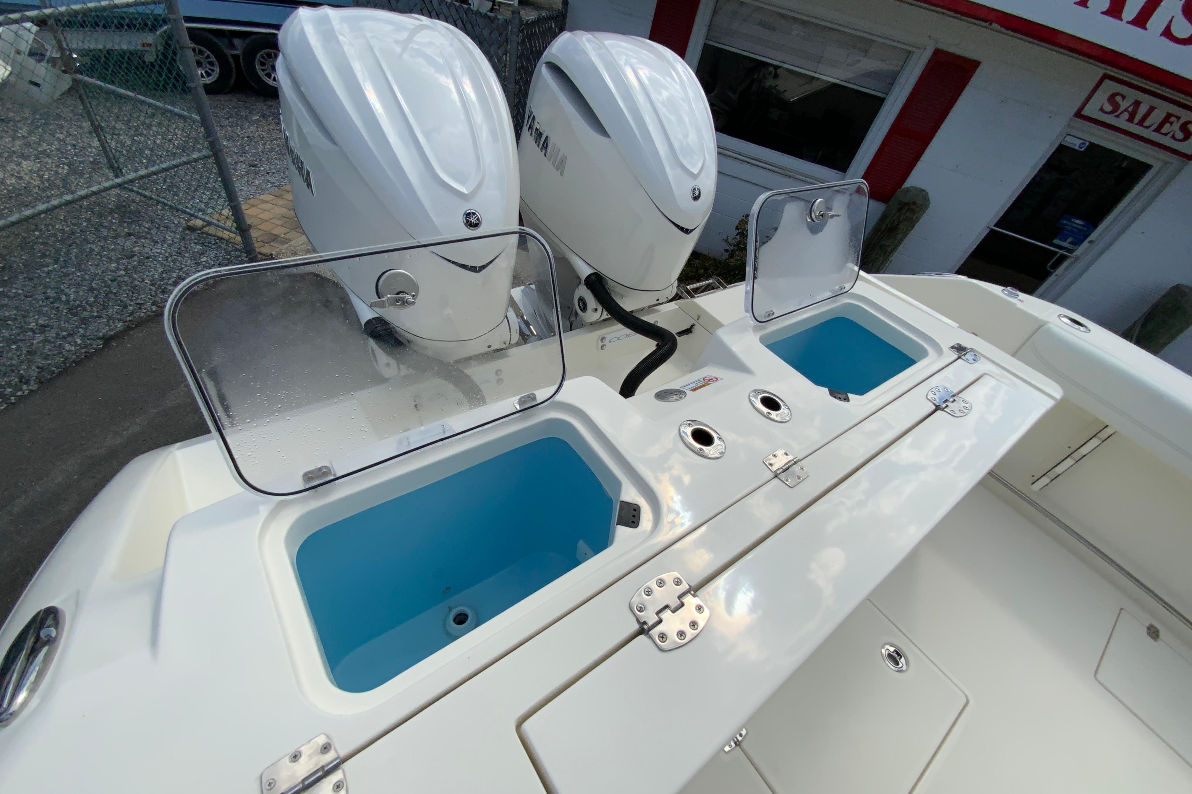 2027 Cobia 320 Center Console with dual Yamaha engines and open storage compartments.