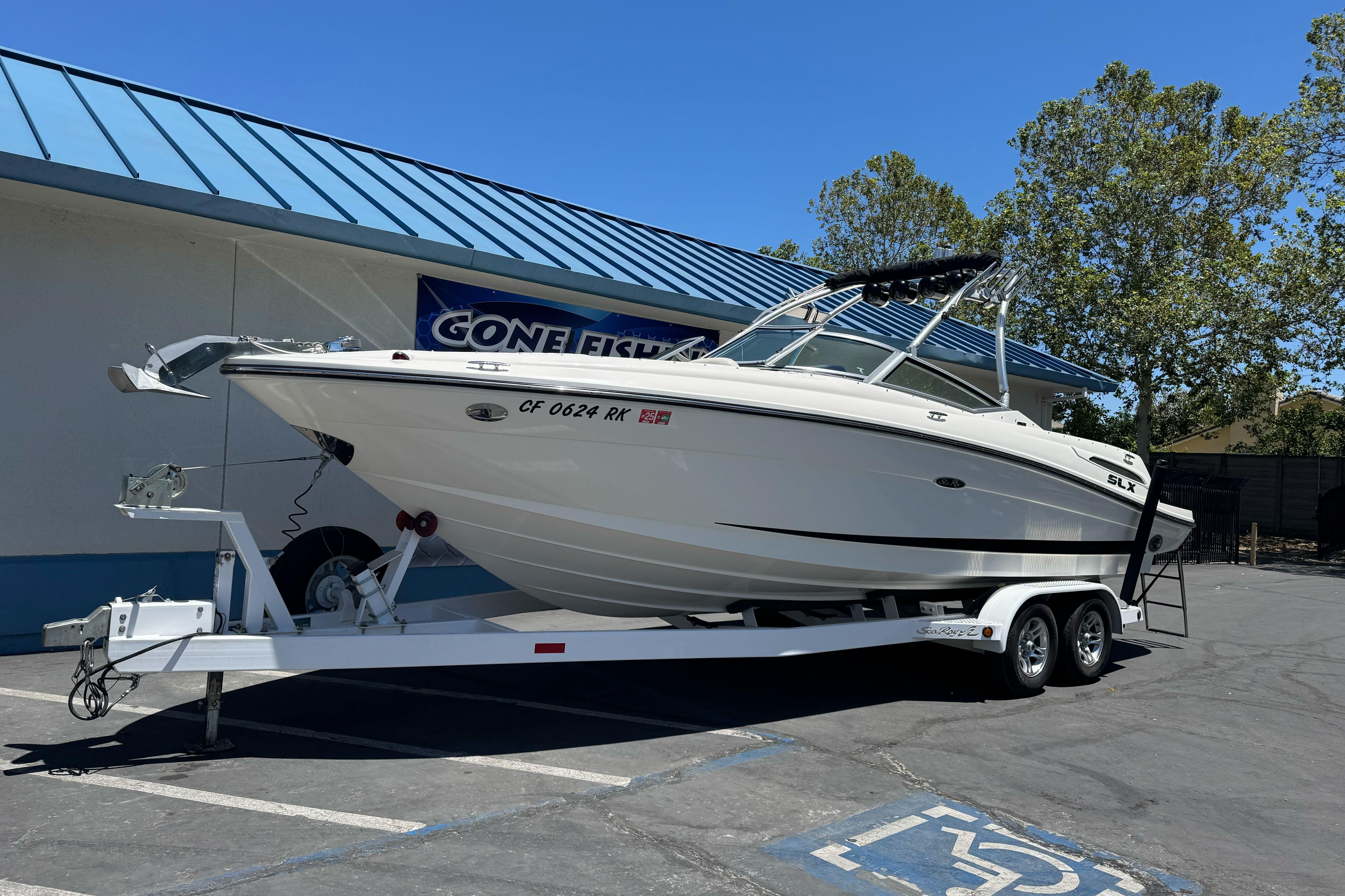 2007 Sea Ray SLX 250 boat on trailer, parked outdoors near a building.