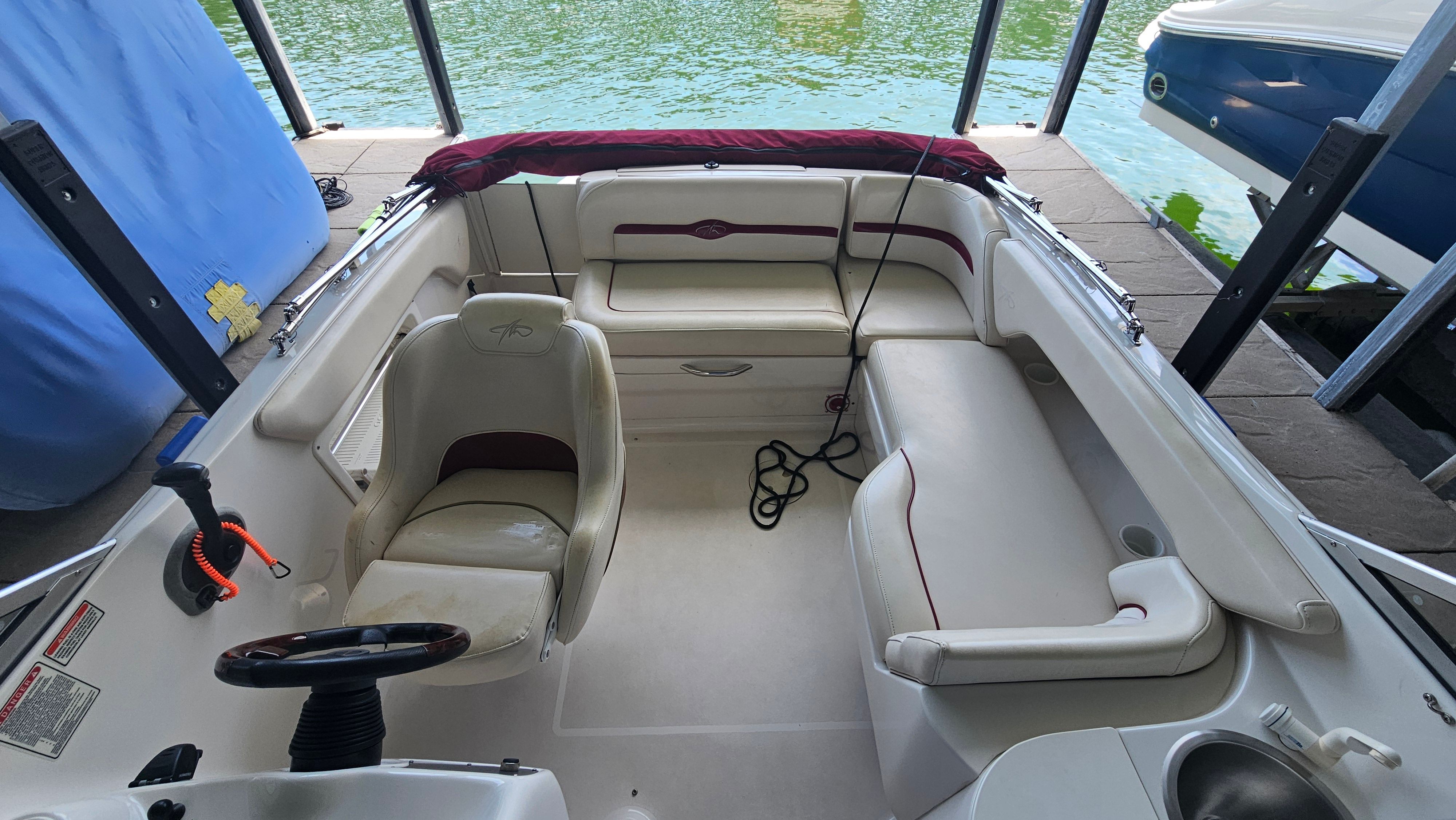 Interior view of a 2002 Monterey 220 Explorer Sport boat with white seating and red accents.