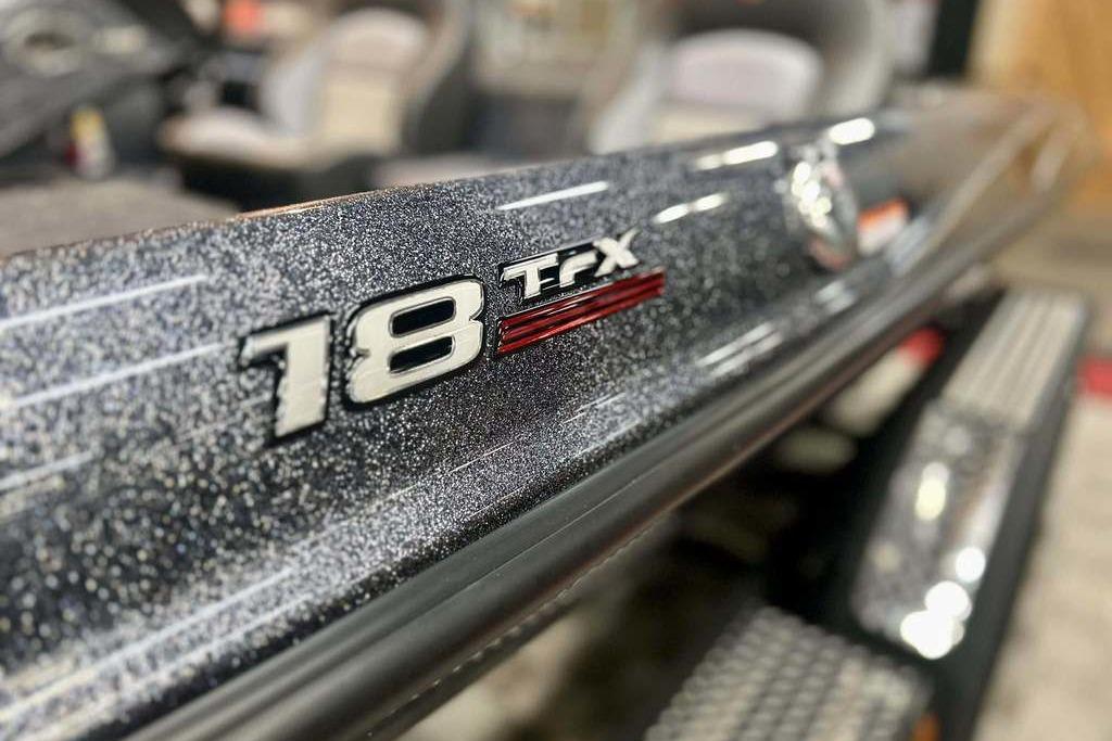 Close-up of 2026 Triton 18 TrX boat model emblem with metallic finish.