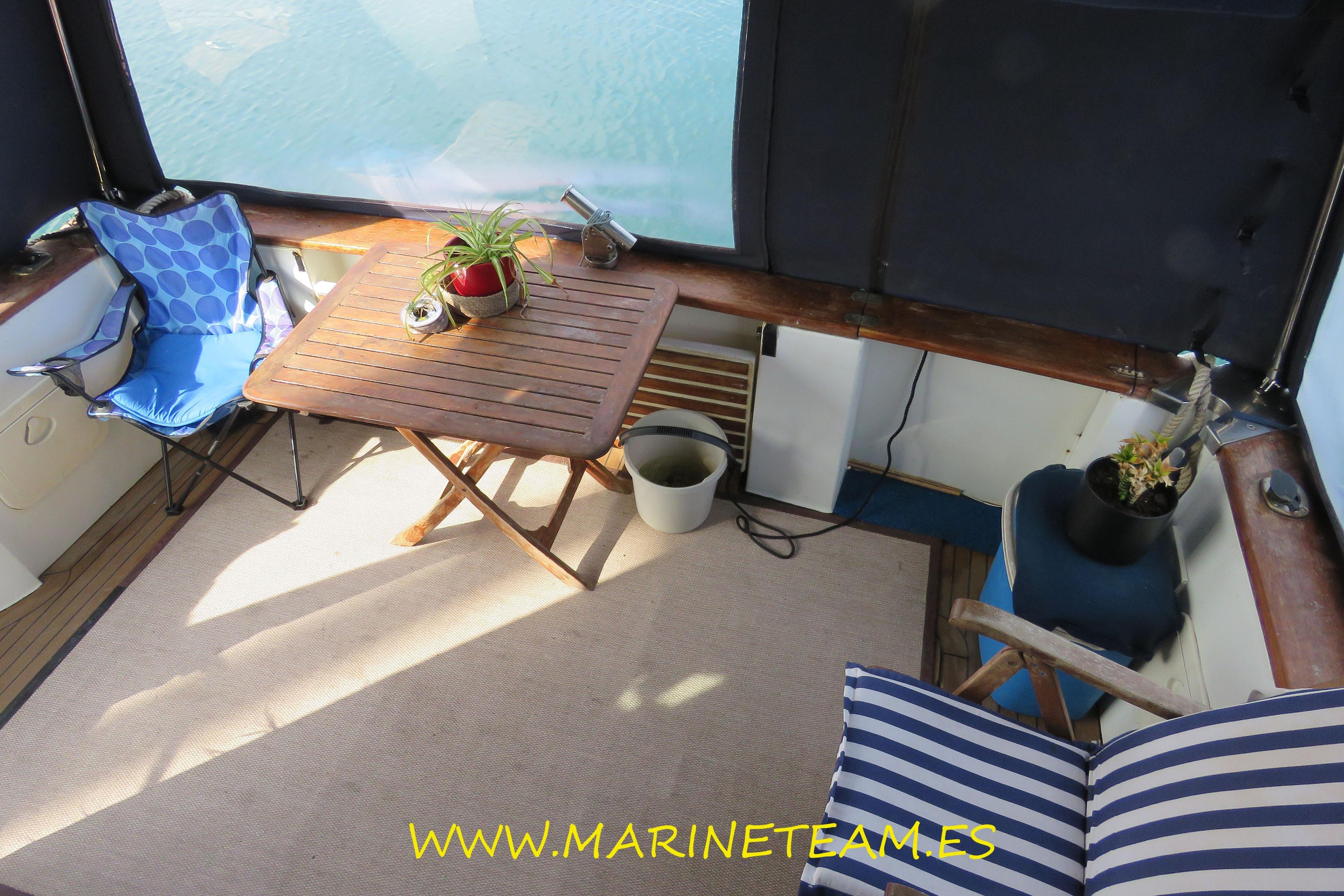 Cozy Starfisher 1060 boat interior with table, chairs, and plants, 2005 model.