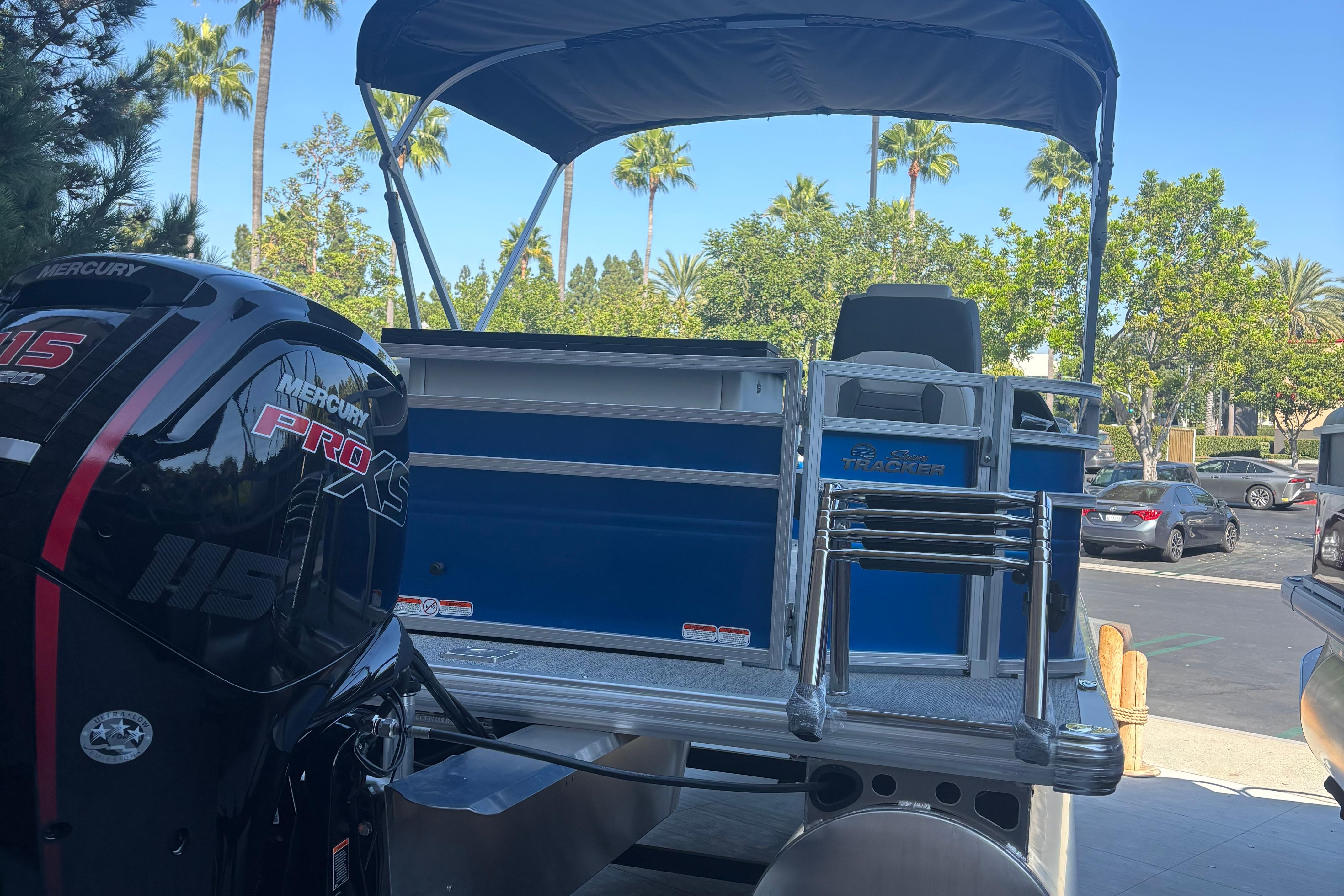 2026 Sun Tracker Fishin' Barge 20 DLX with Mercury Pro XS engine in a sunny parking lot.