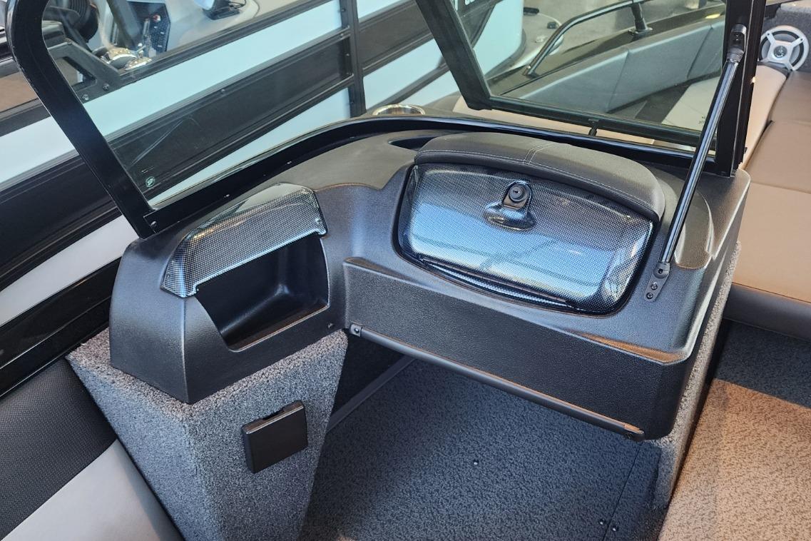 Interior of a 2023 Lowe boat featuring a dashboard and storage compartment.