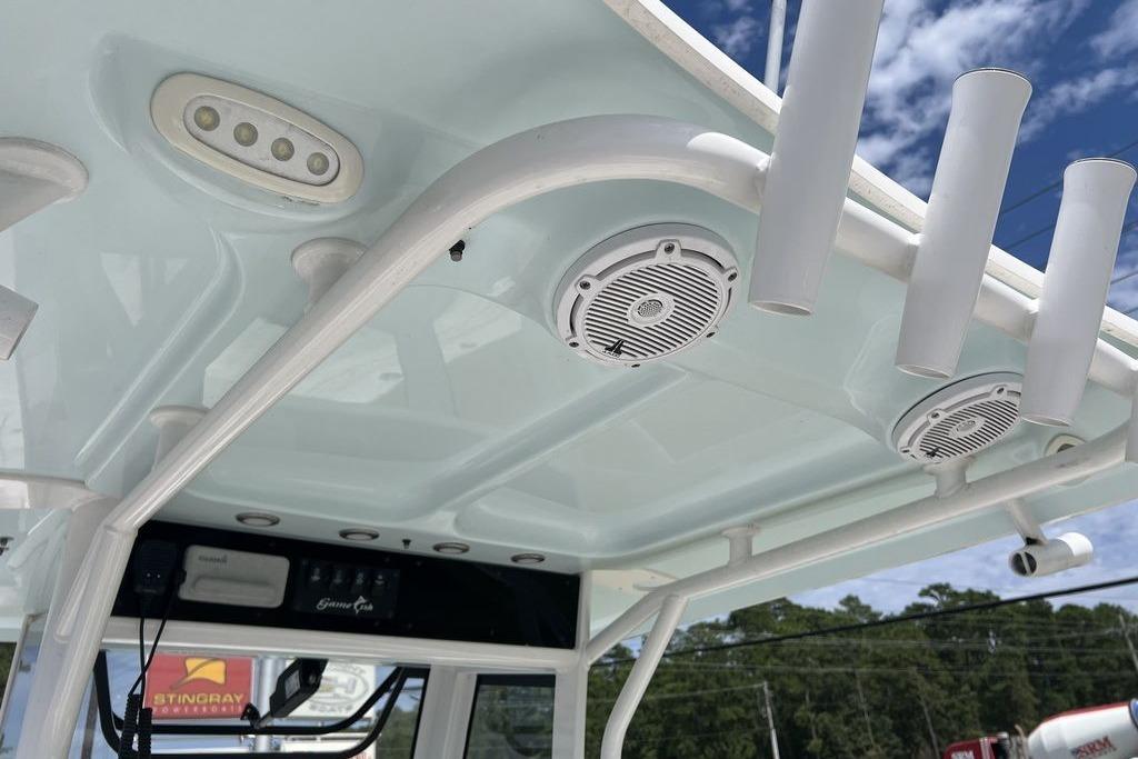 2021 Sea Hunt Gamefish 25 boat T-top with speakers and rod holders under a blue sky.
