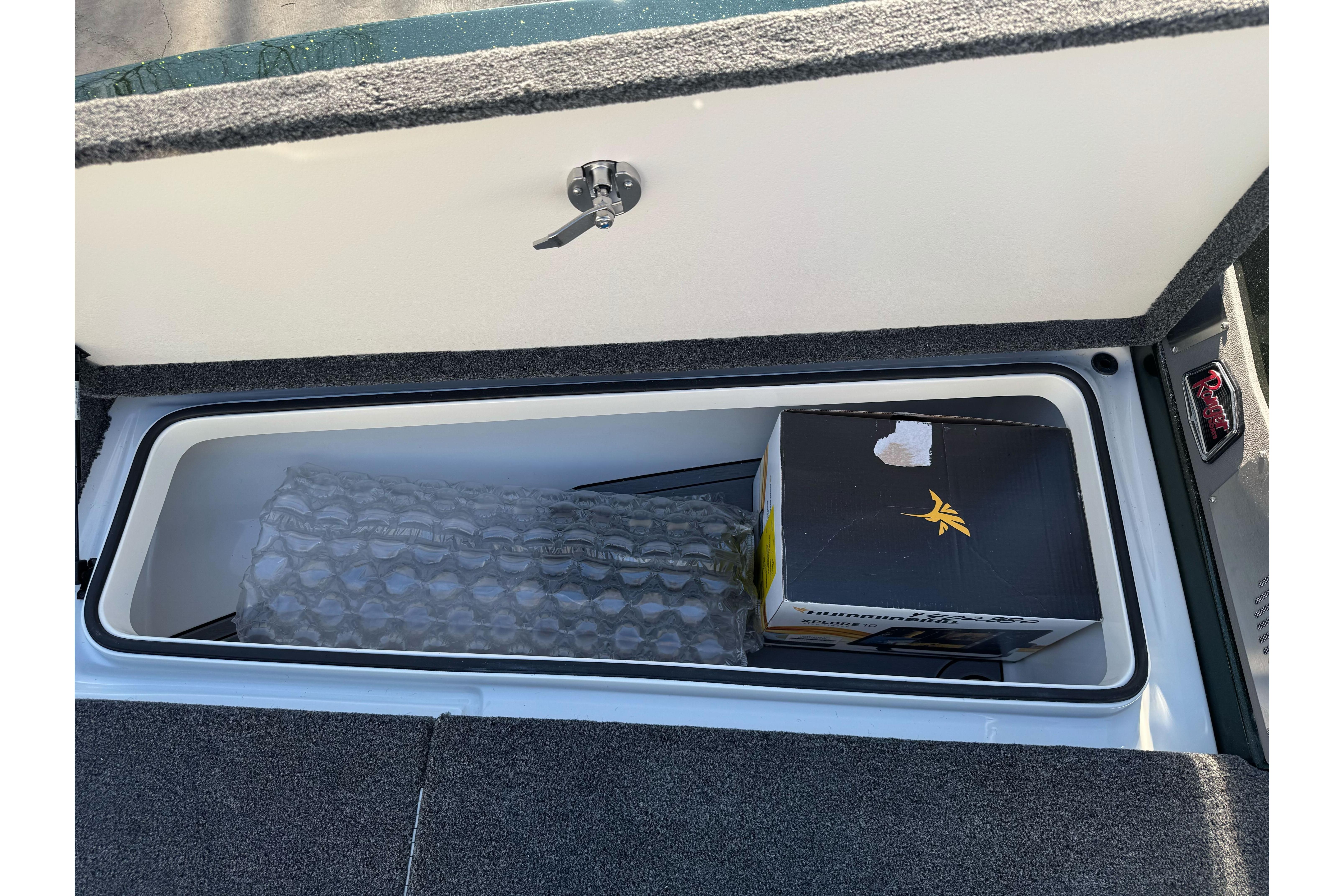 Storage compartment in 2026 Ranger 620xFS Pro boat, containing a box and bubble wrap.