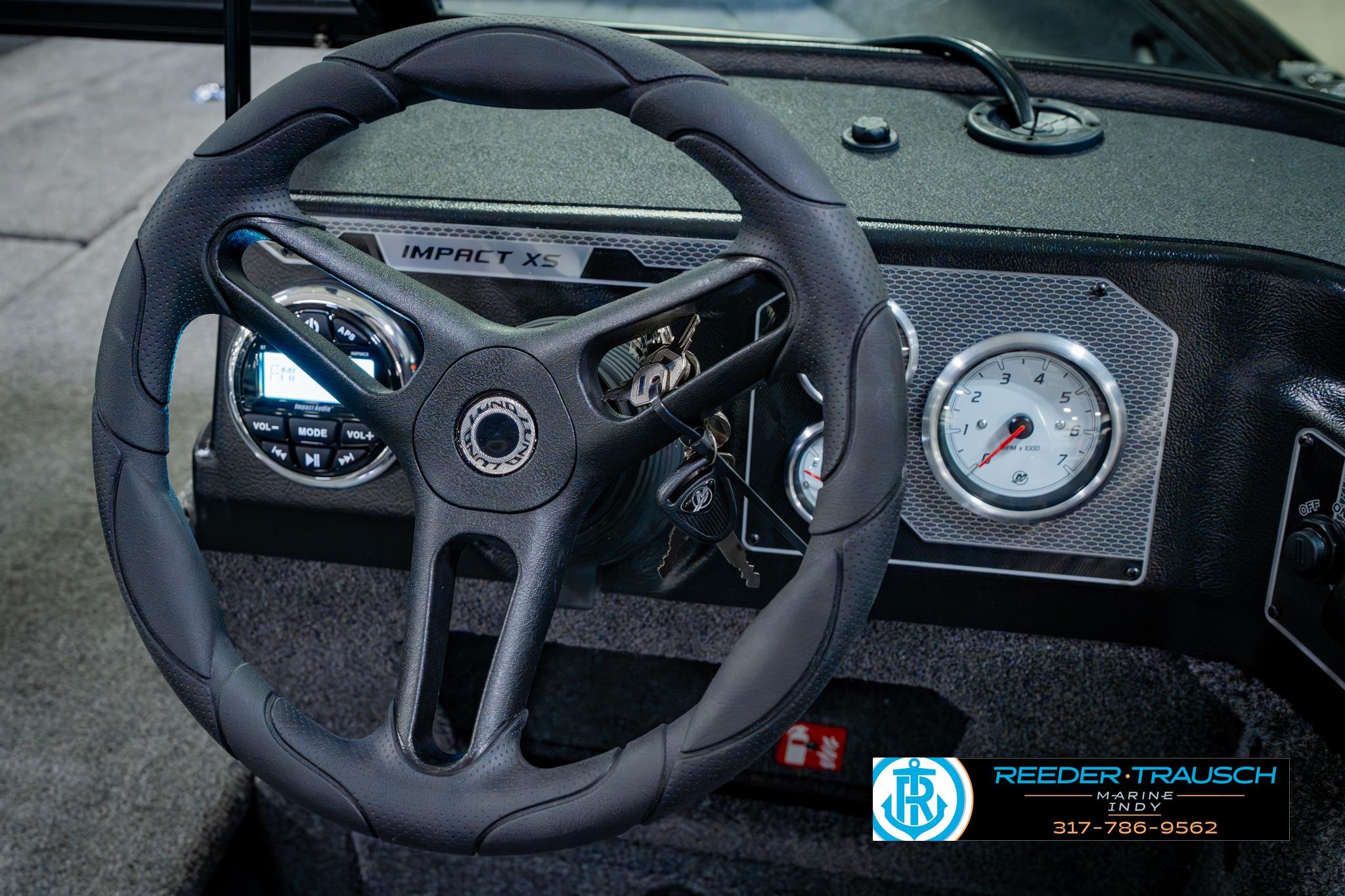 2026 Lund 1875 Impact XS boat dashboard with steering wheel and gauges.