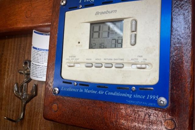 Thermostat on 1979 Pearson 365 Ketch, displaying temperature settings, mounted on wooden panel.