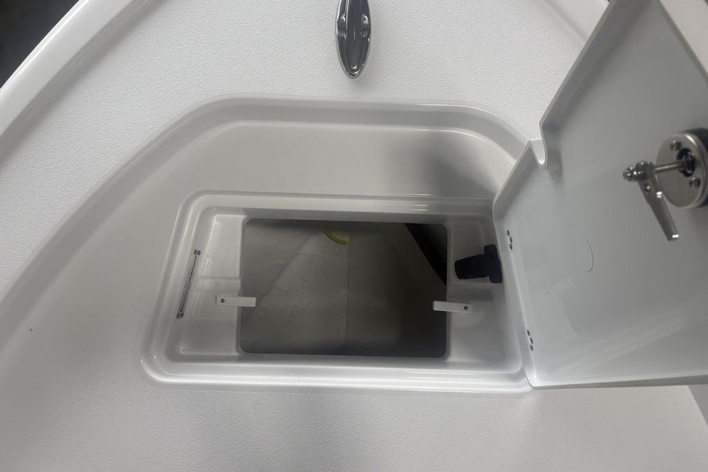 Open storage compartment on 2026 Sportsman Masters 227 boat, featuring a secure latch.