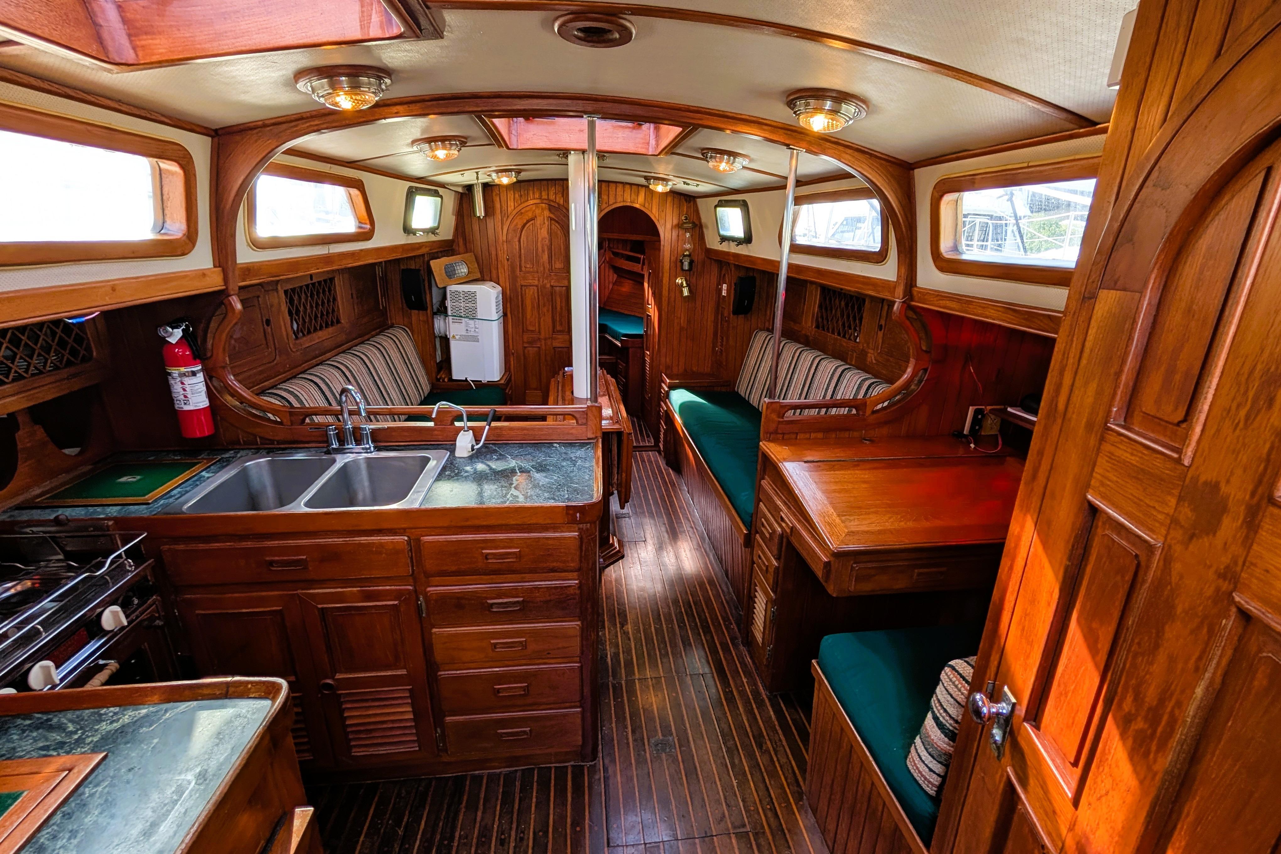 Interior of 1983 Robert Perry 41 sailboat with wooden furnishings and cozy seating.