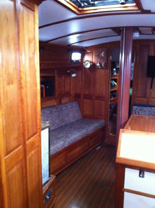 Interior of 1981 Southern Cross 39' yacht with wooden furnishings and cozy seating area.